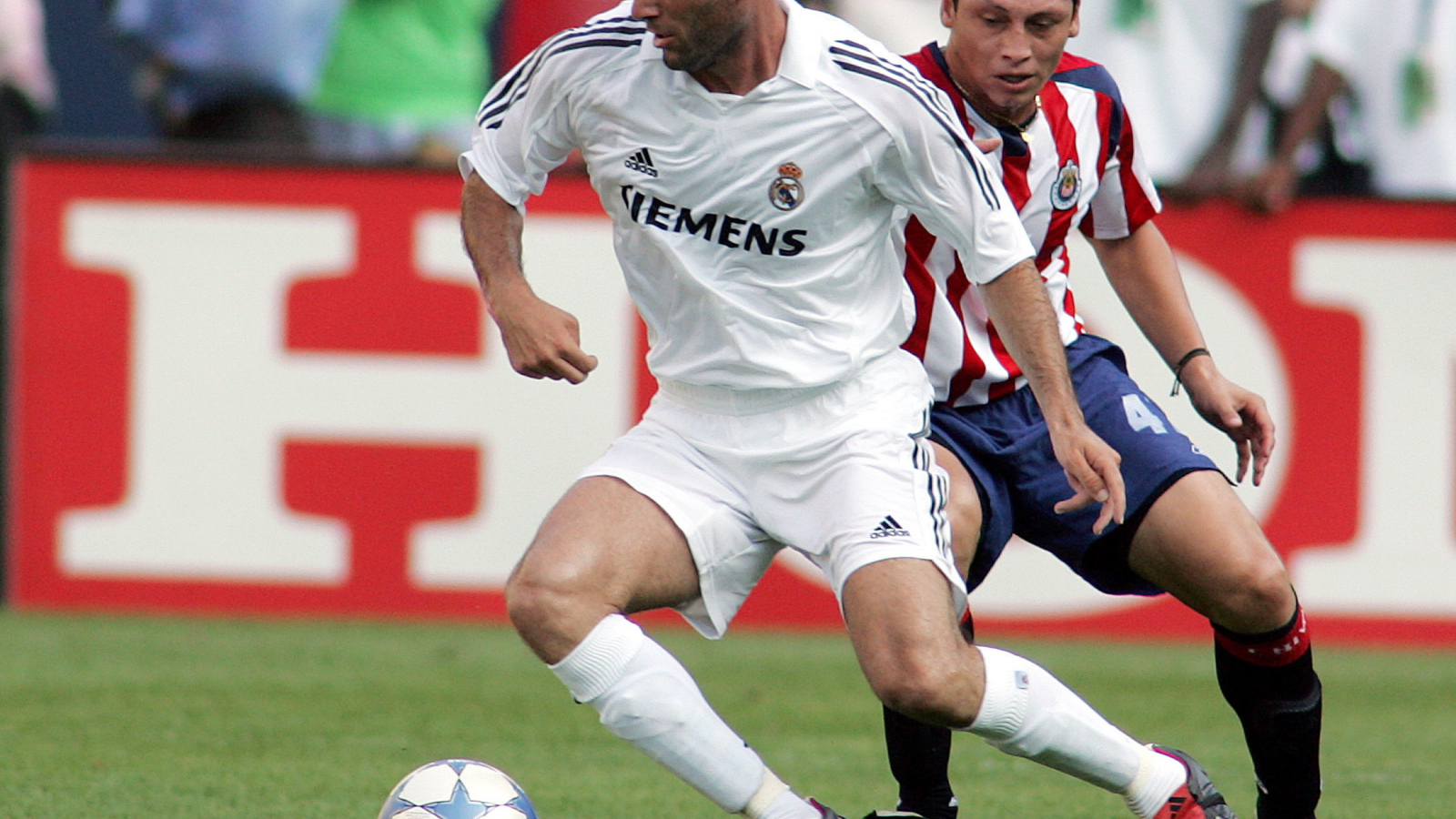 Легенда футбола Зинедин Зидан передавая мяч