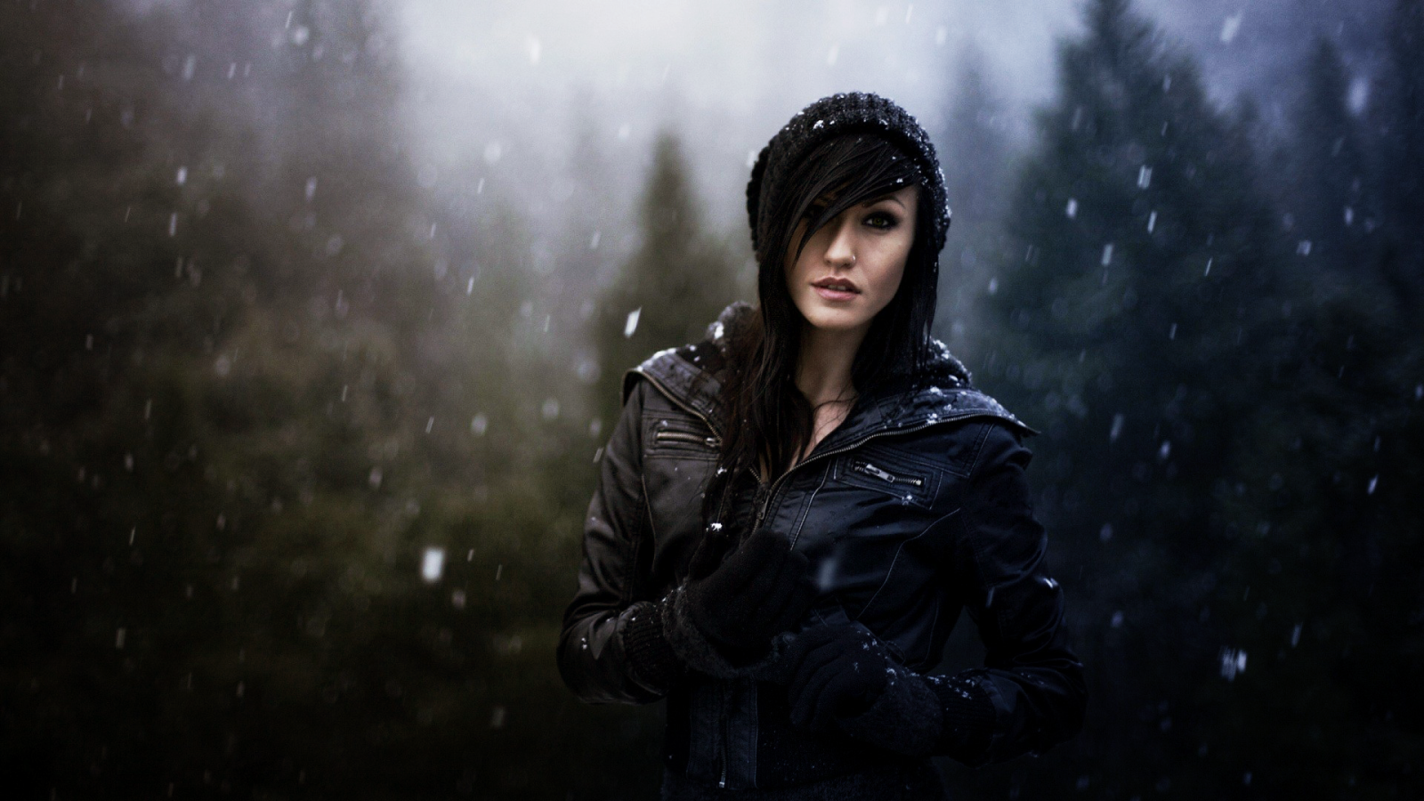 Брюнетка в куртке под снегом