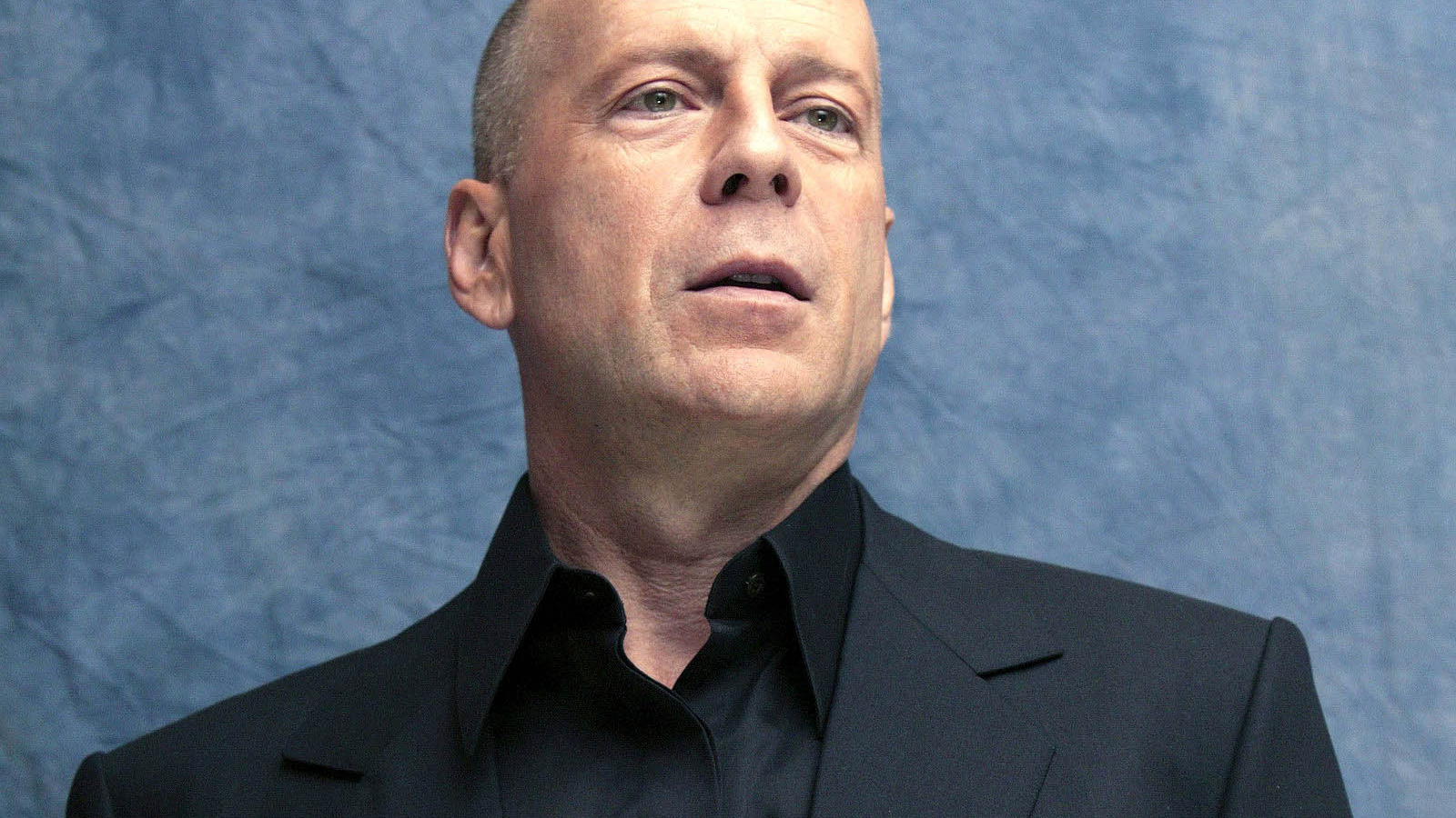 Известный актер Брюс Уиллис на синем фоне