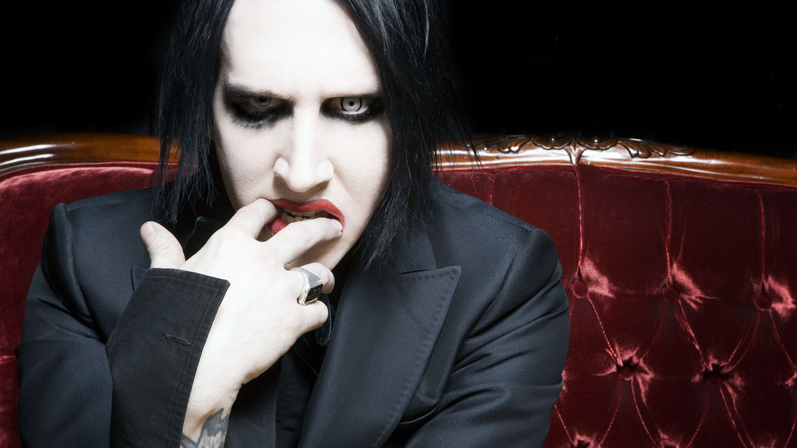 Marilyn Manson on a red couch