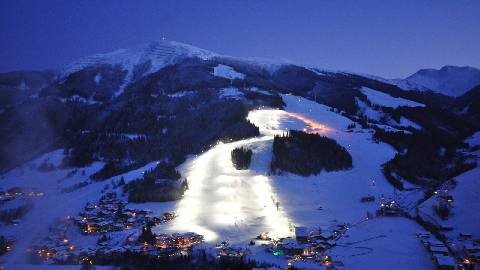Вечерняя подсветка лыжной трассы на горнолыжном курорте Заальбах Хинтерглем, Австрия