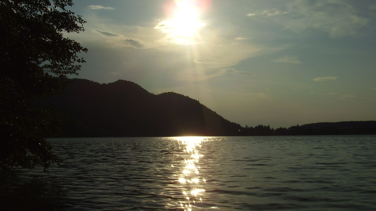 Солнце над водой озера Клопайнер Зее, Австрия