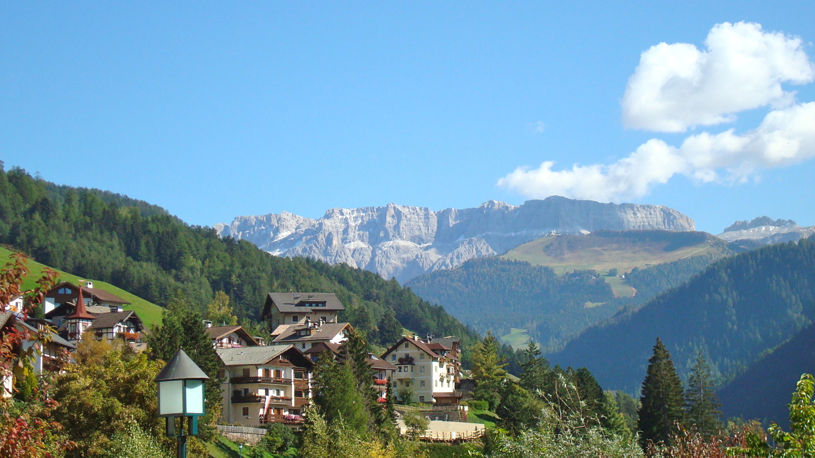 Дома на склоне горы на курорте Ортизей, Италия