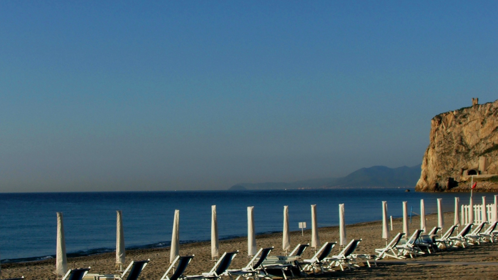 Лежаки на пляже на курорте Финале Лигуре, Италия