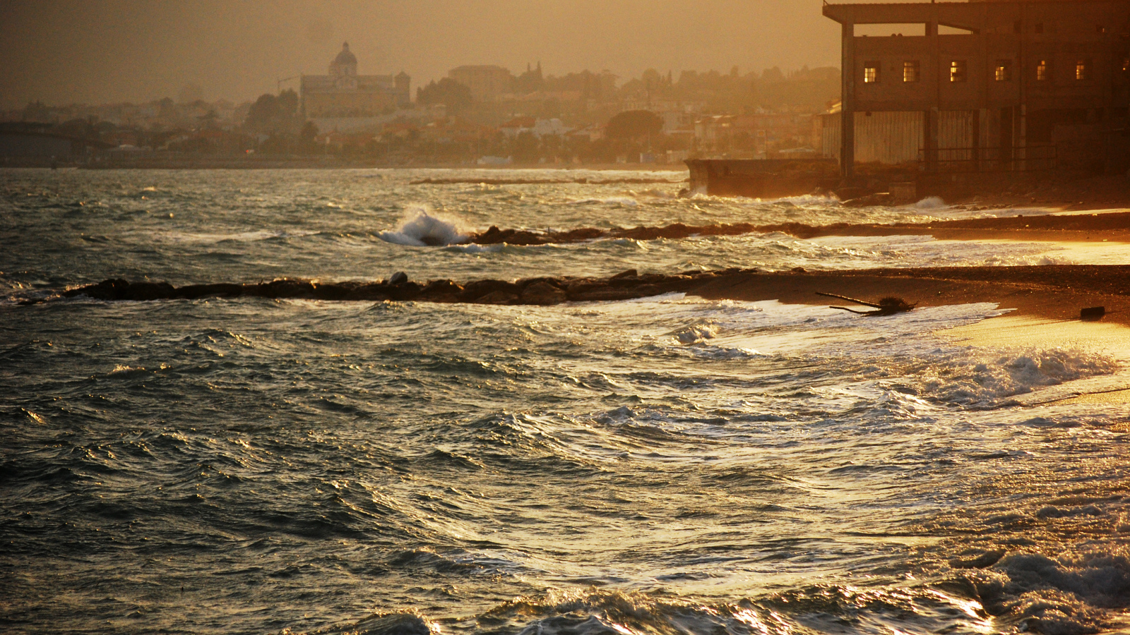 Закат на пляже на курорте в Пьетра Лигуре, Италия
