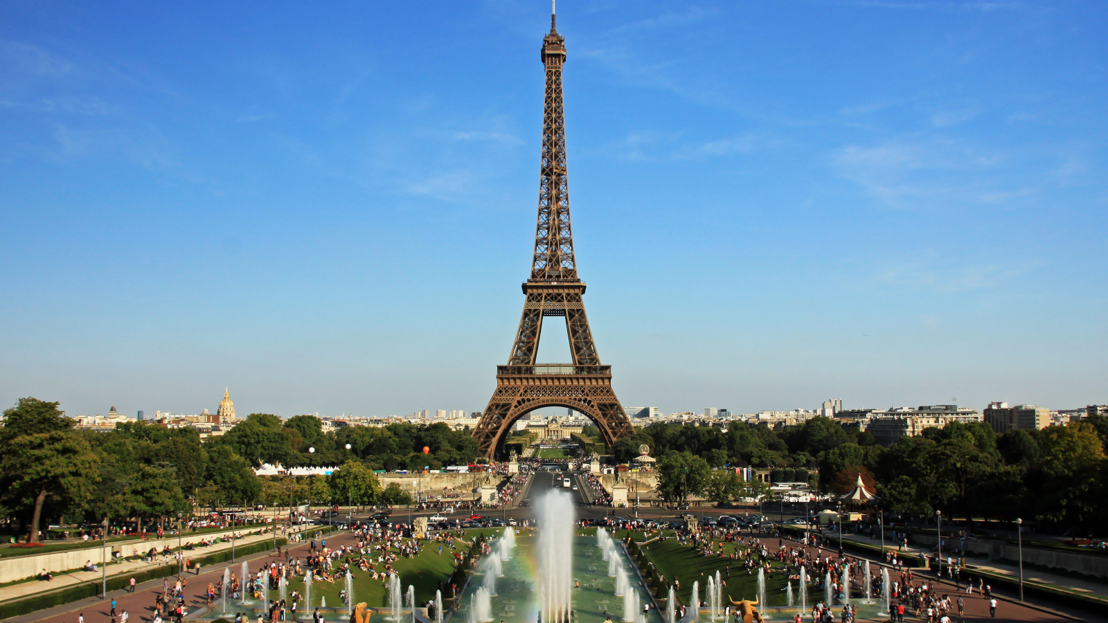 People rest near the Eiffel Tower and fountains