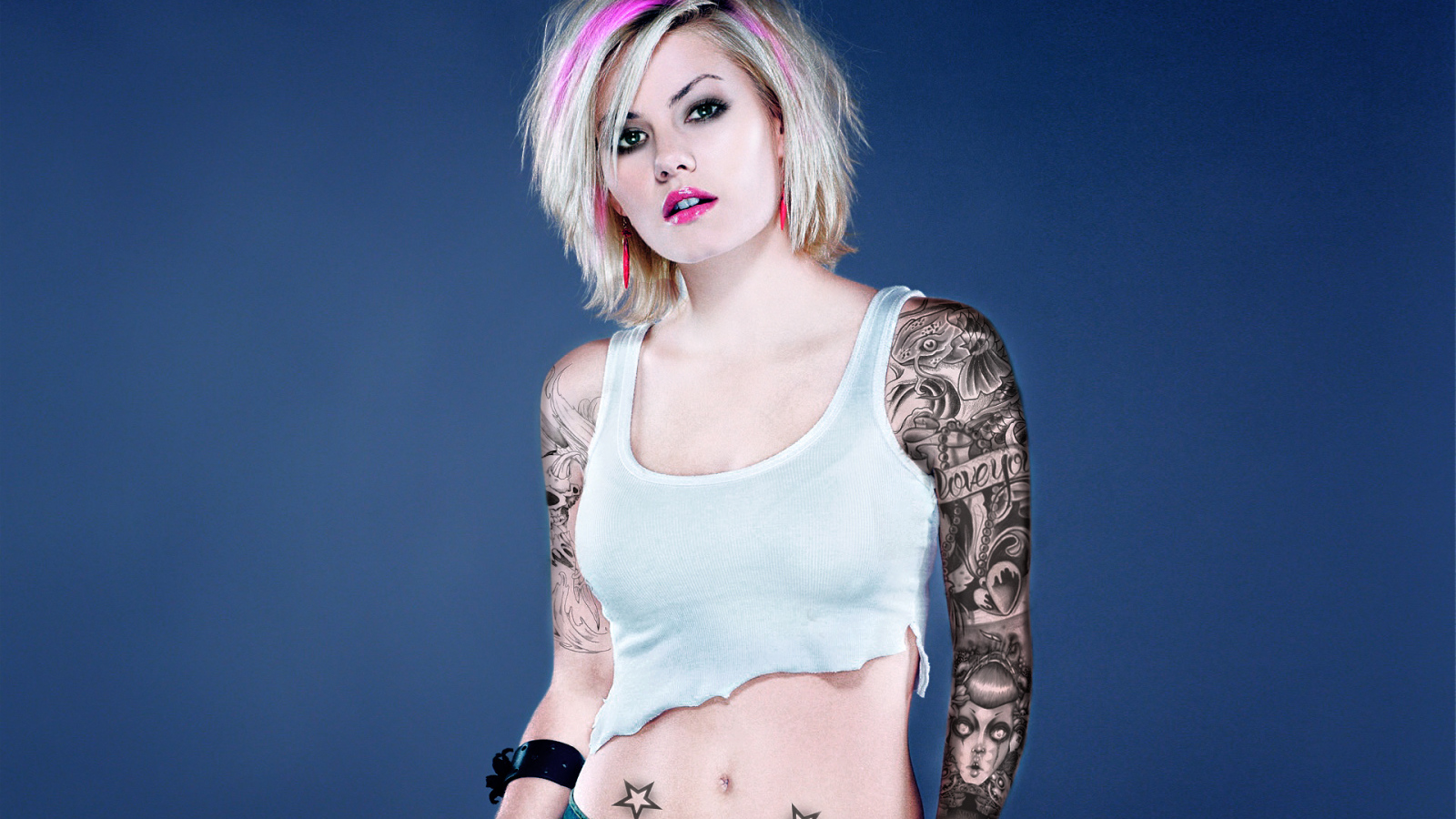 Девушка бунтарка с татуировками на руке и животе