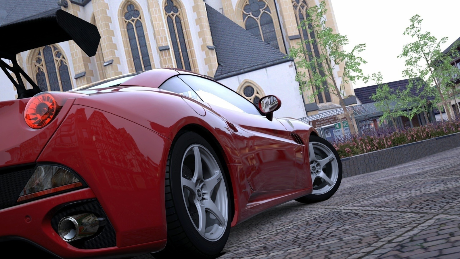 Красный спортивный автомобиль на площади у собора