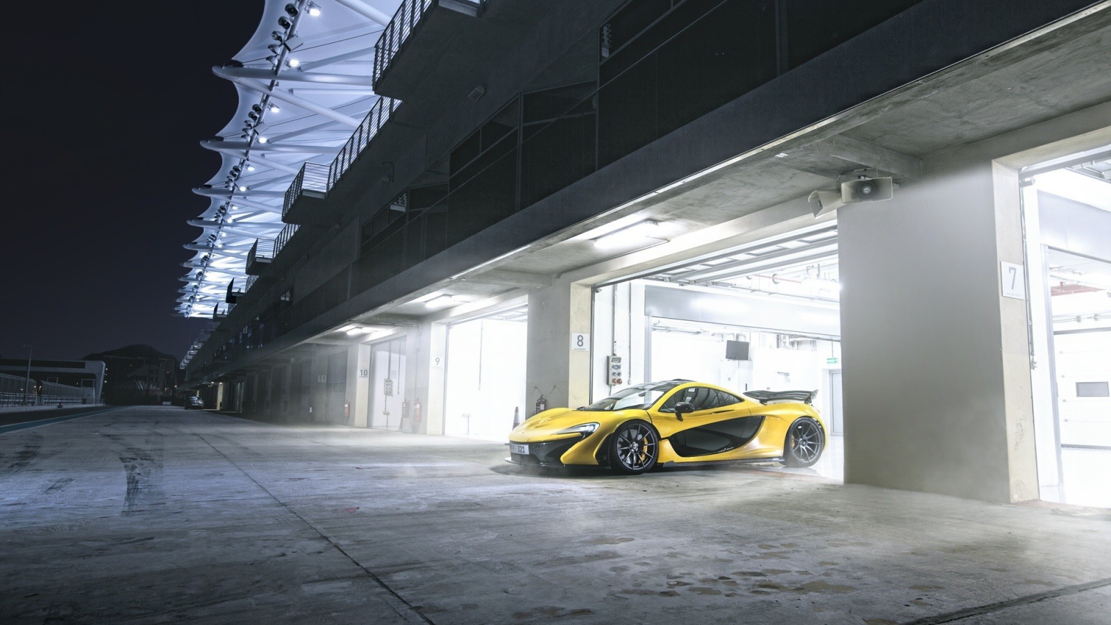 Желтый McLaren выезжает из гаража