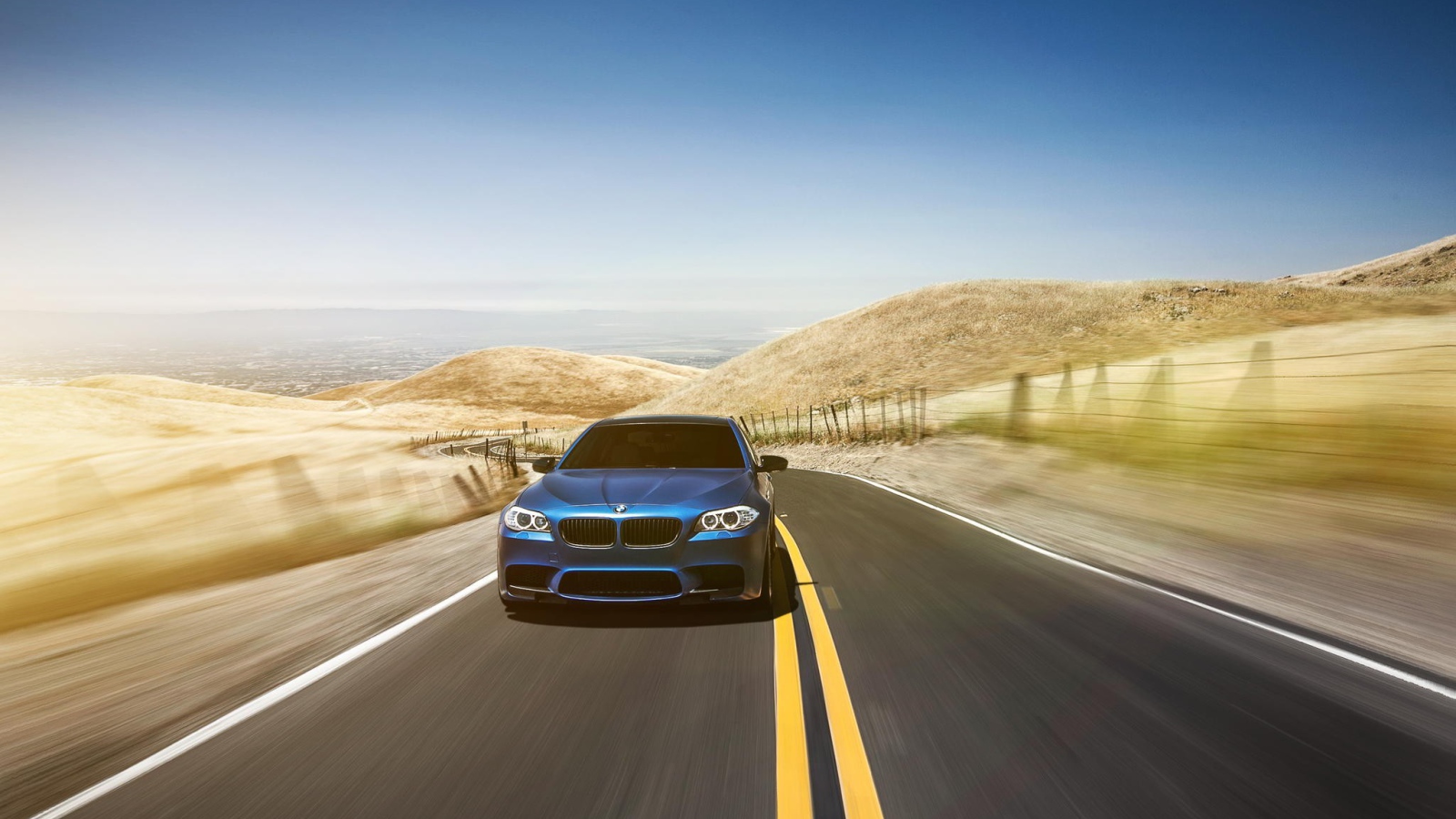 Голубой BMW мчится по шоссе в пустыне