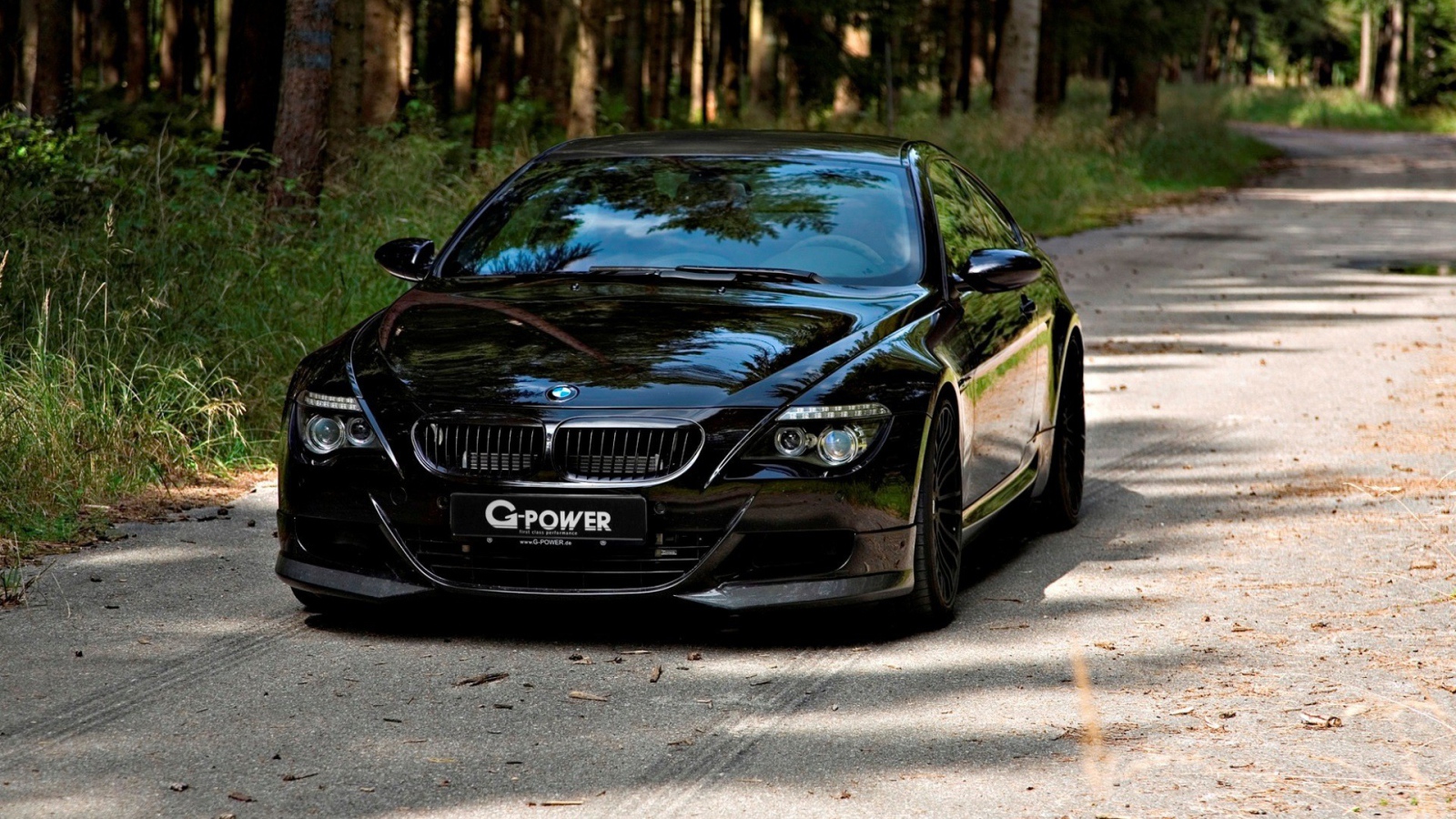 Черный BMW M6 Hurricane RR на проселочной дороге в лесу