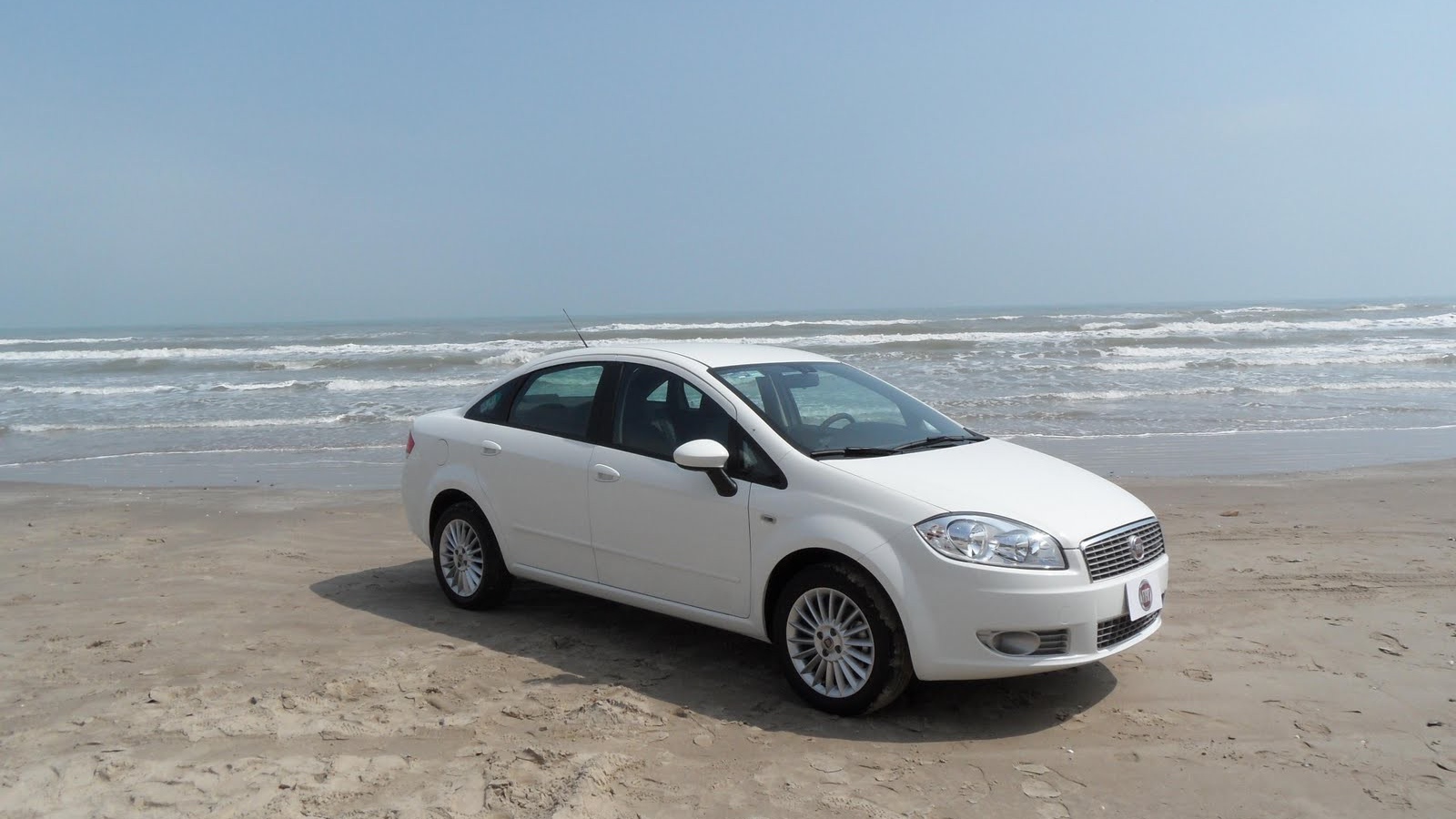 Белый Фиат на песке пляжа