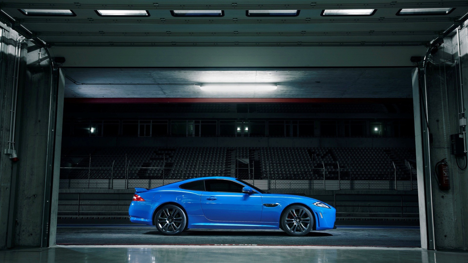 Голубой Jaguar XKR-S на стадионе