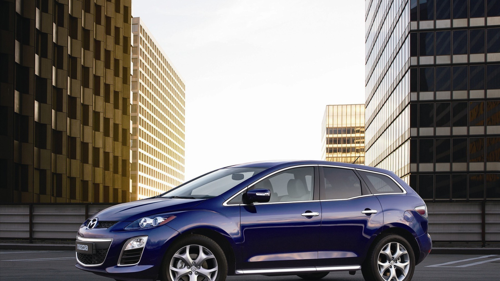 Семейный автомобиль Мазда на фоне городских зданий
