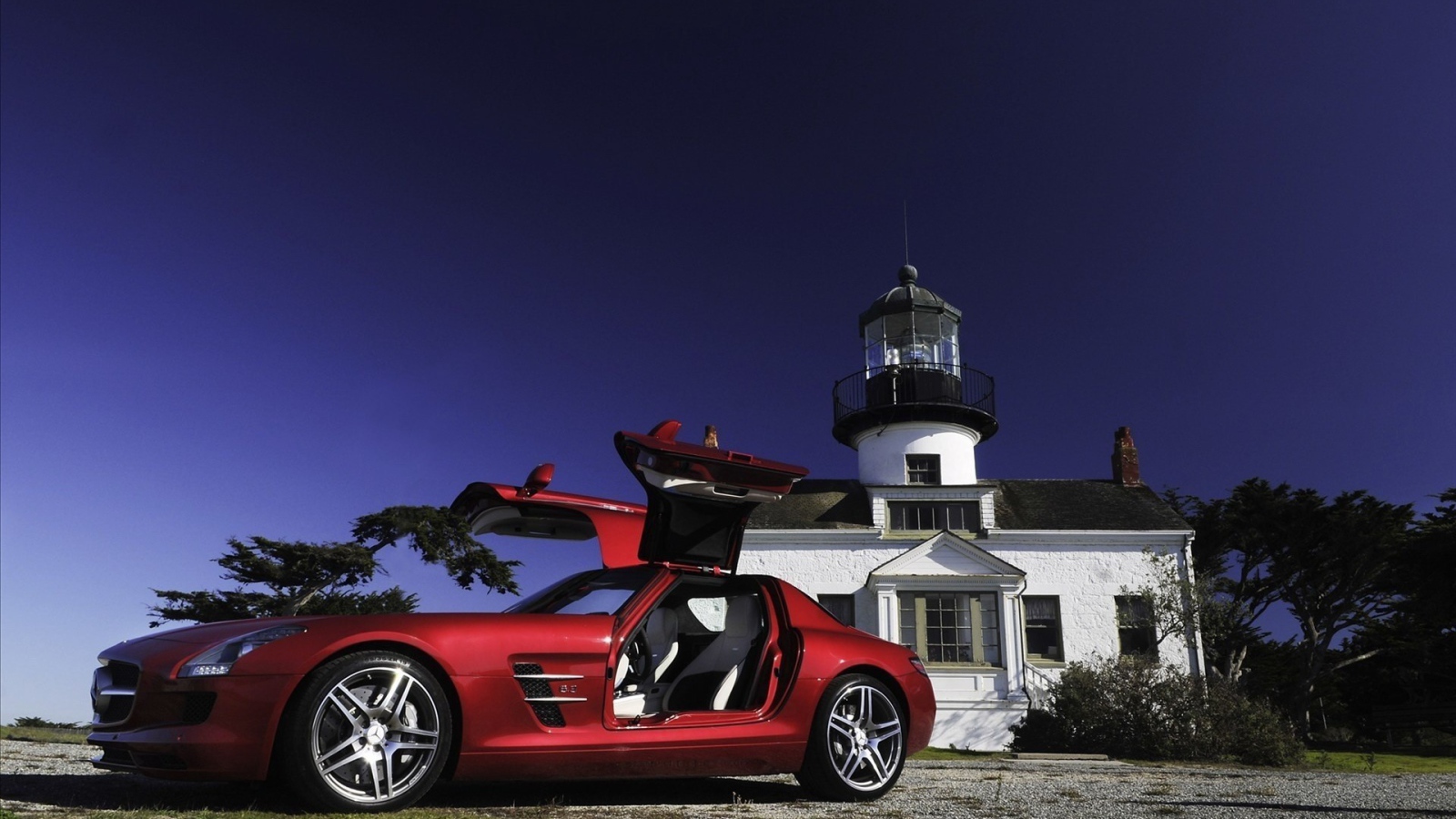 Красный Mercedes SLS у маяка