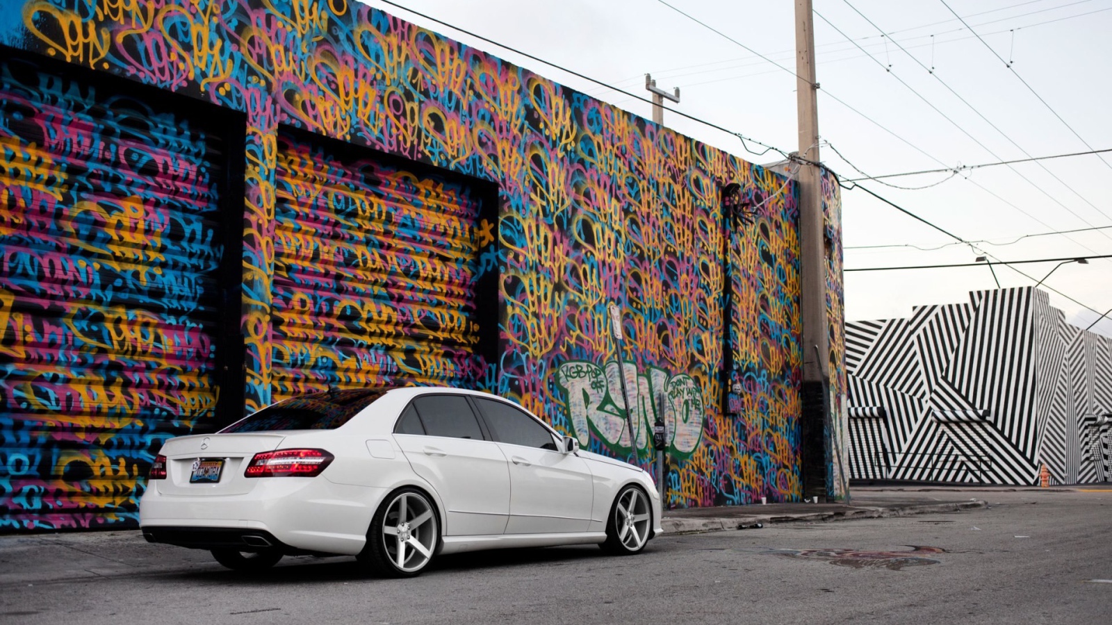 Белый Mercedes-Benz у раскрашенного гаража