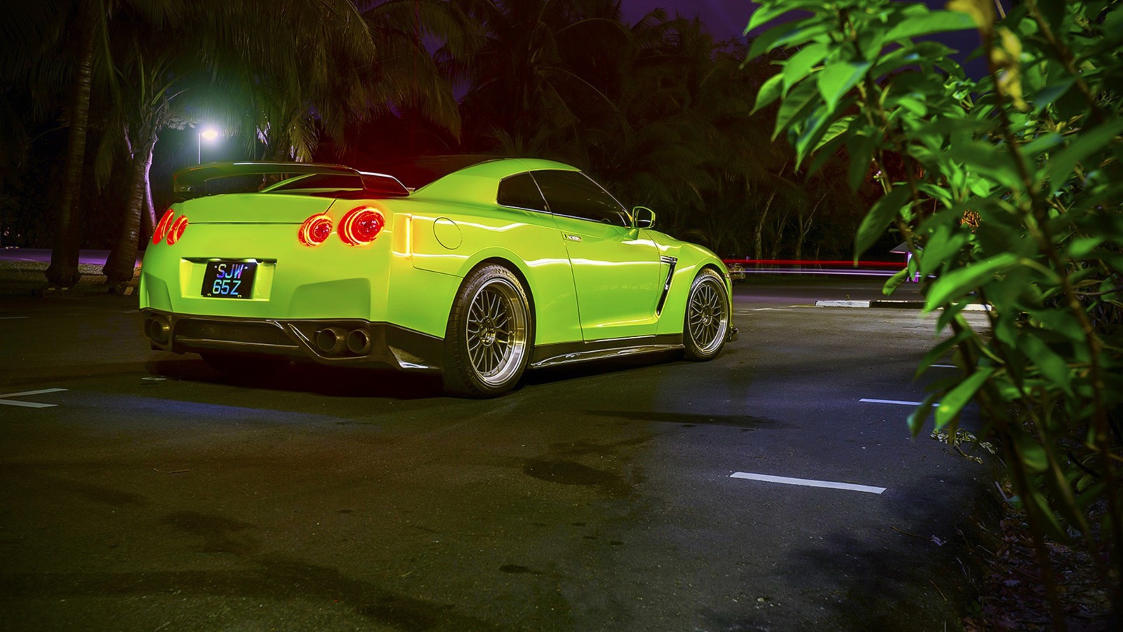 Зеленый спортивный Nissan на ночной улице города