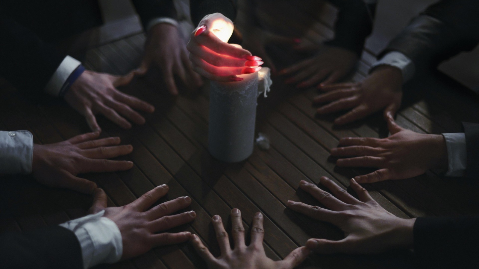 Люди вызывают духа при помощи свечи