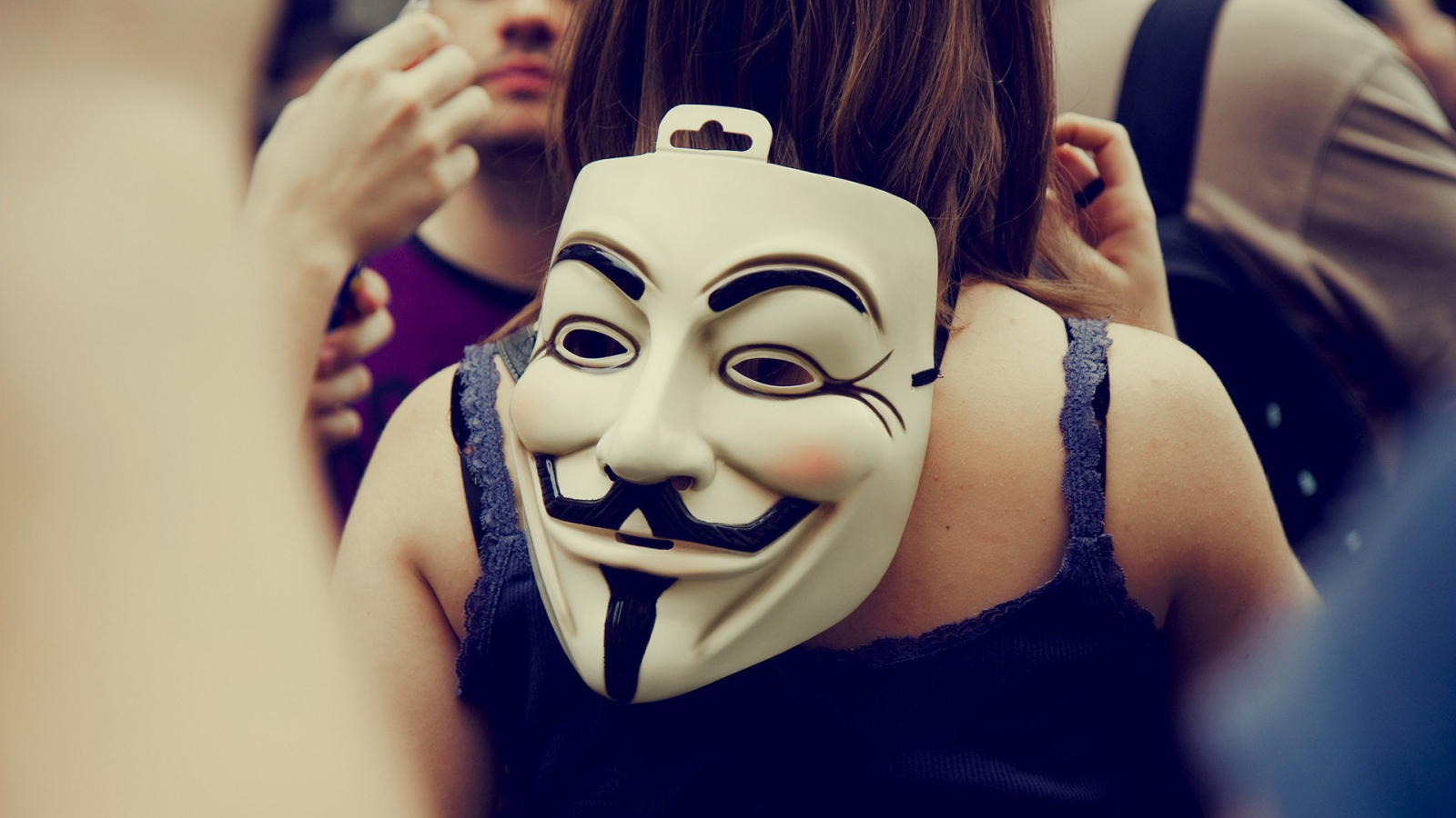 Маска Анонимуса на затылке девушки