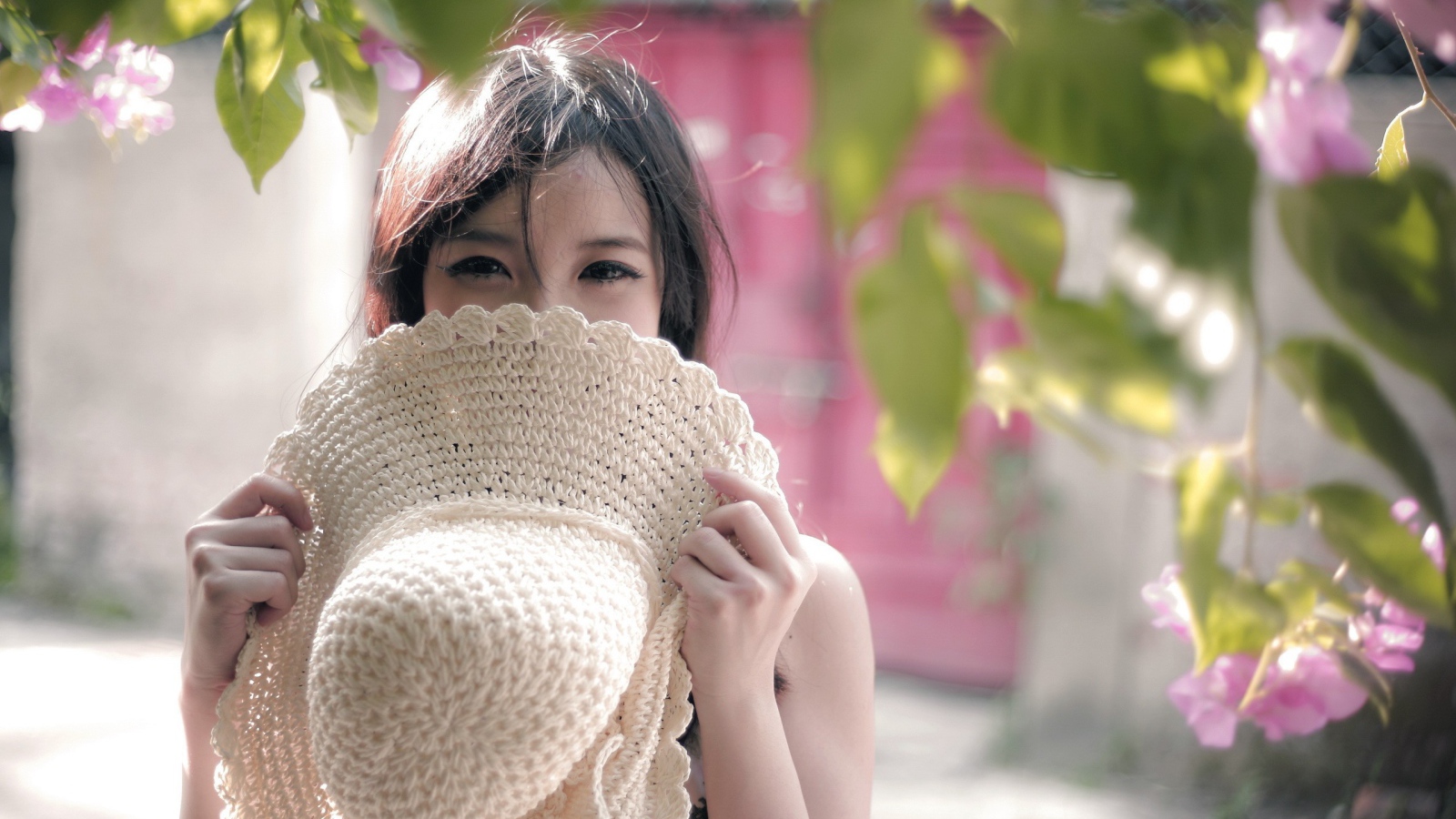 Азиатская девушка прикрыла лицо шляпой