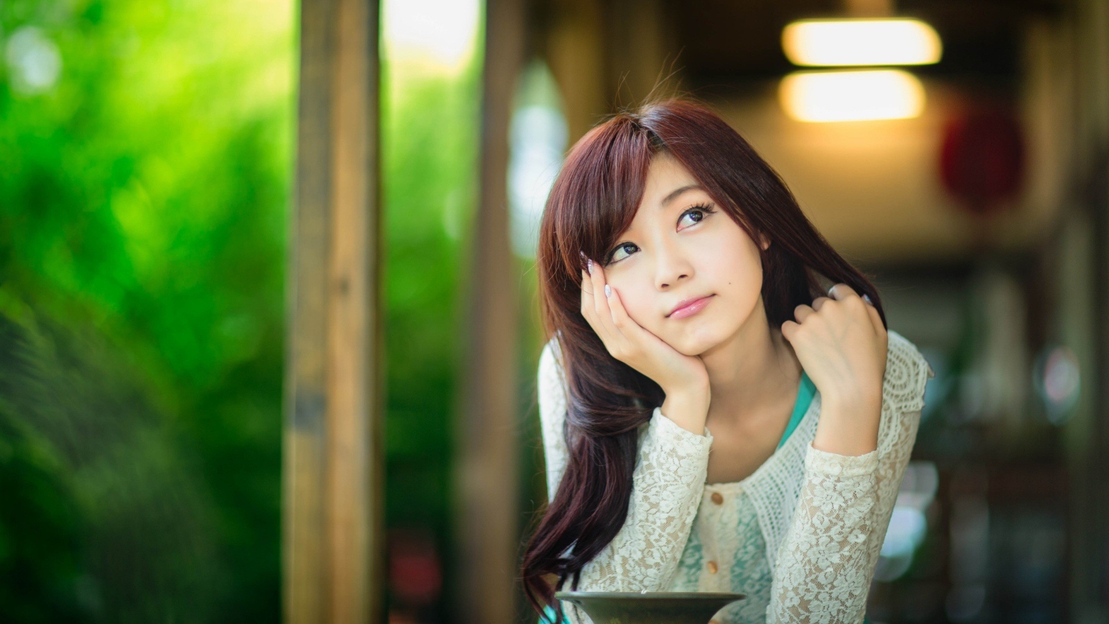 Азиатская девушка задумчиво смотрит вверх