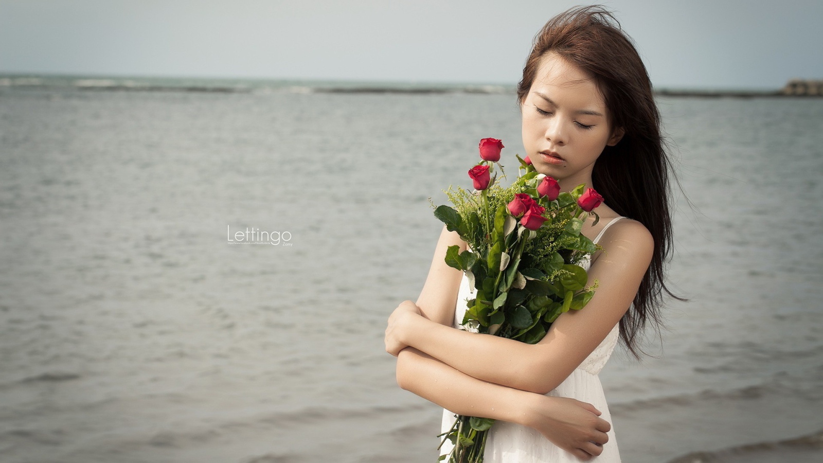 Азиатка держит в руках букет роз