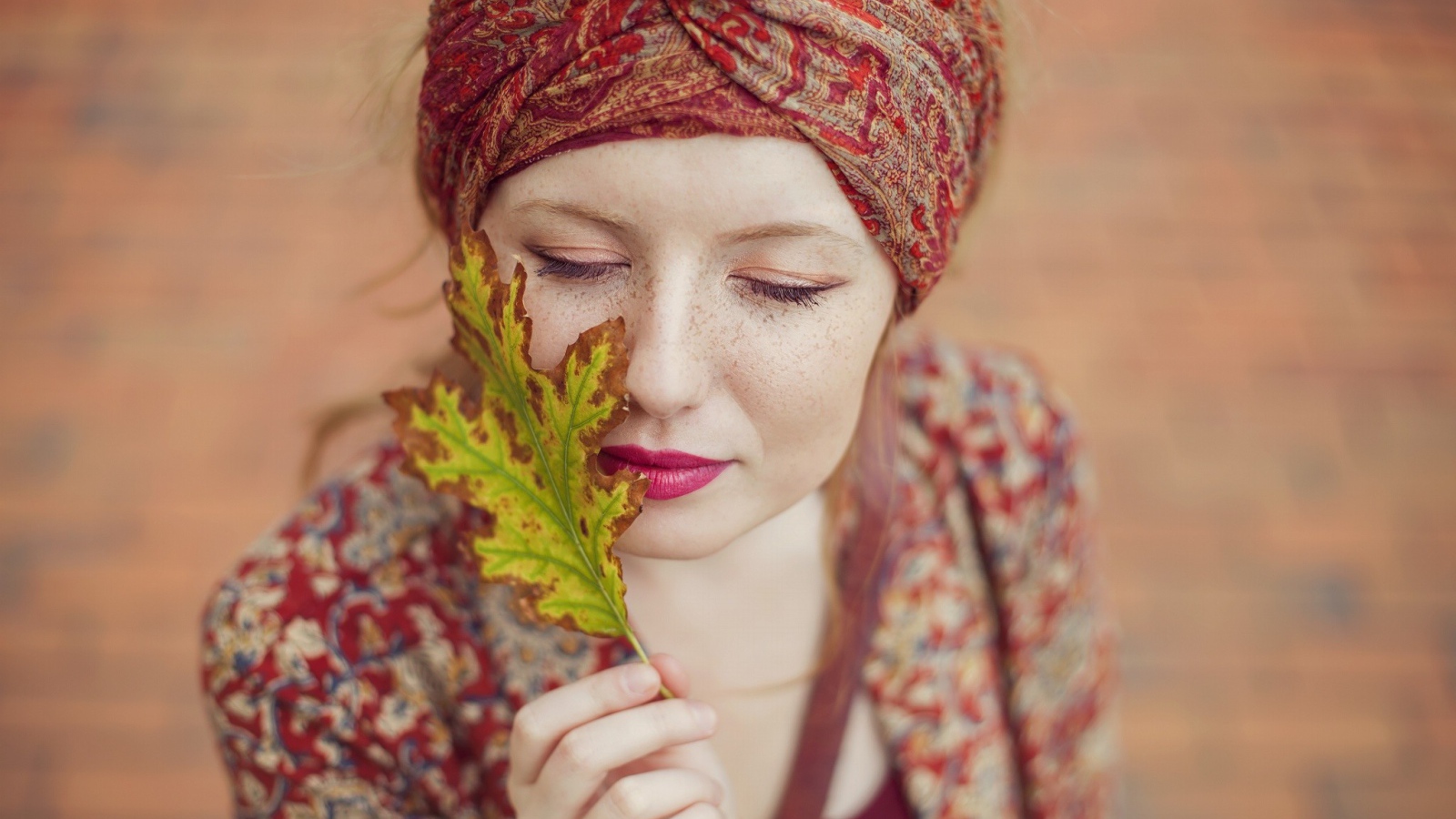 Девушка в традиционном наряде держит в руке лист