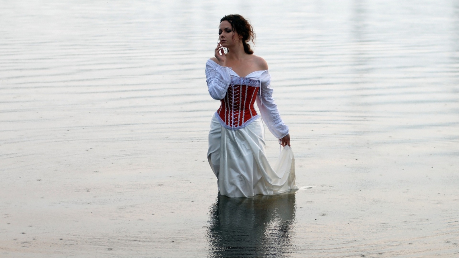 Girl in white dress standing in water