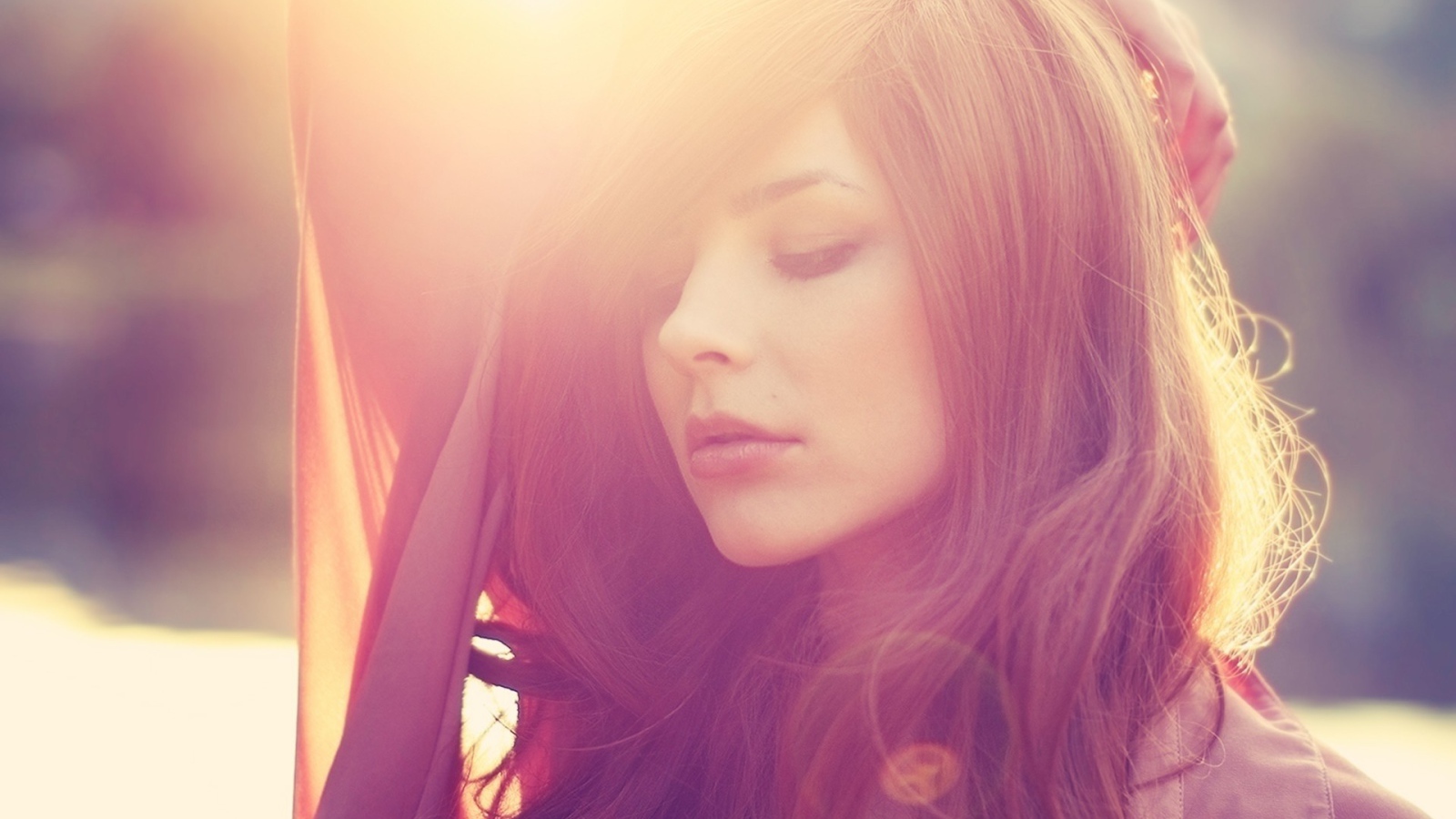 Девушка с каштановыми волосами в лучах солнца