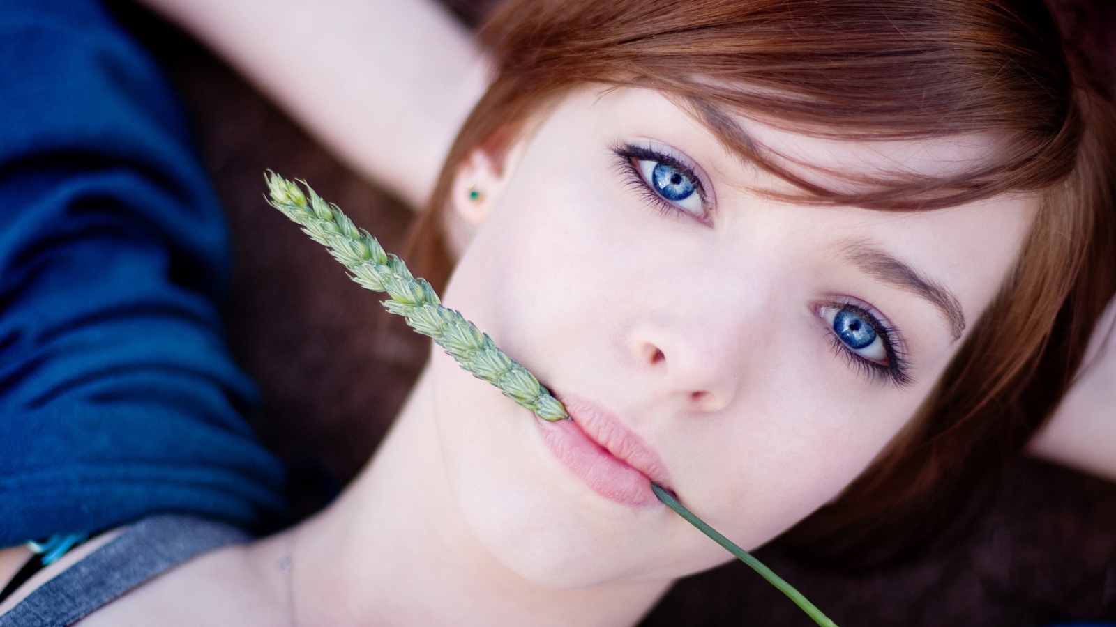 Зеленый колосок во рту у девушки