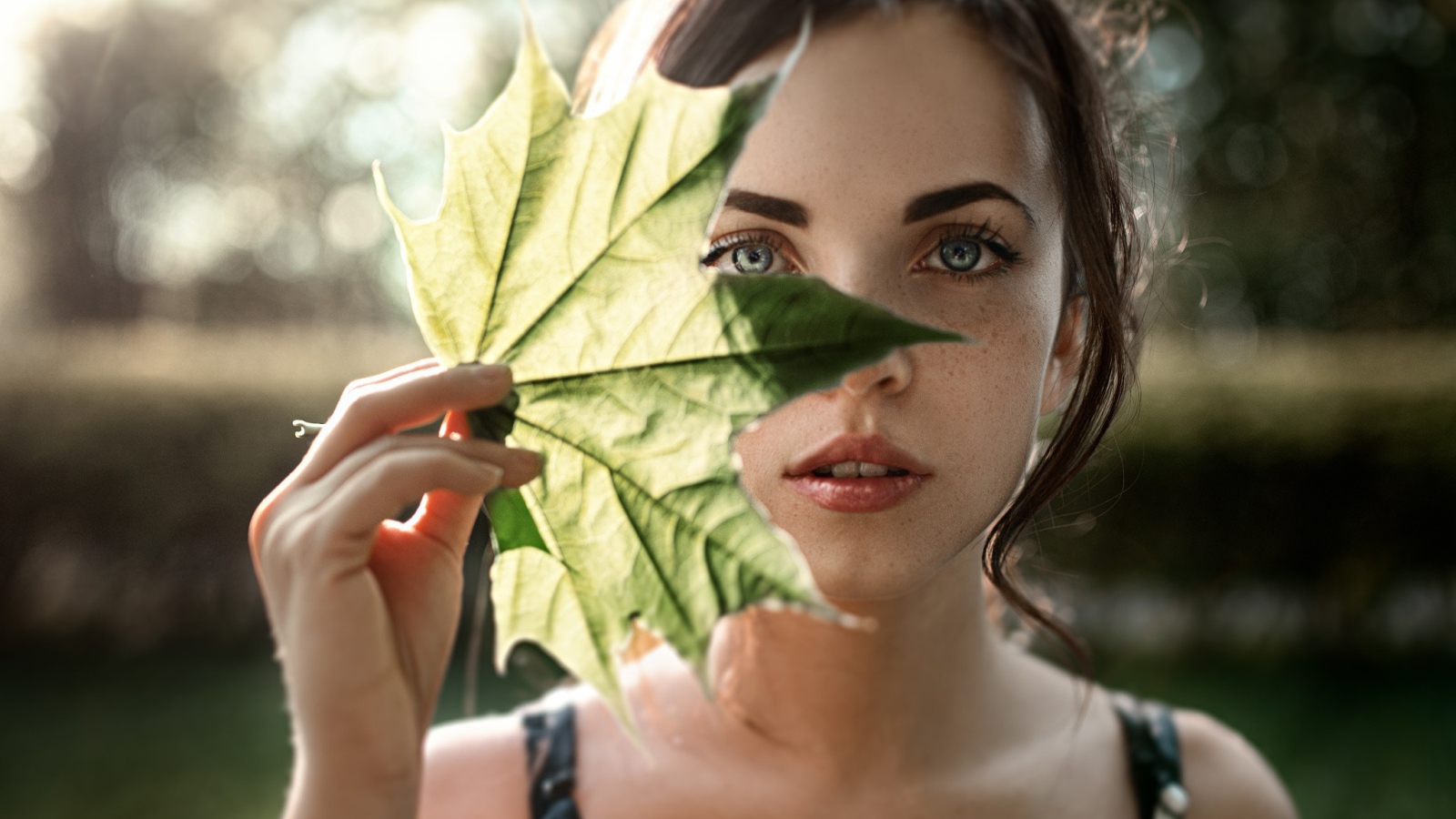 Девушка закрывает лицо листом, фото Георгий Чернядьев