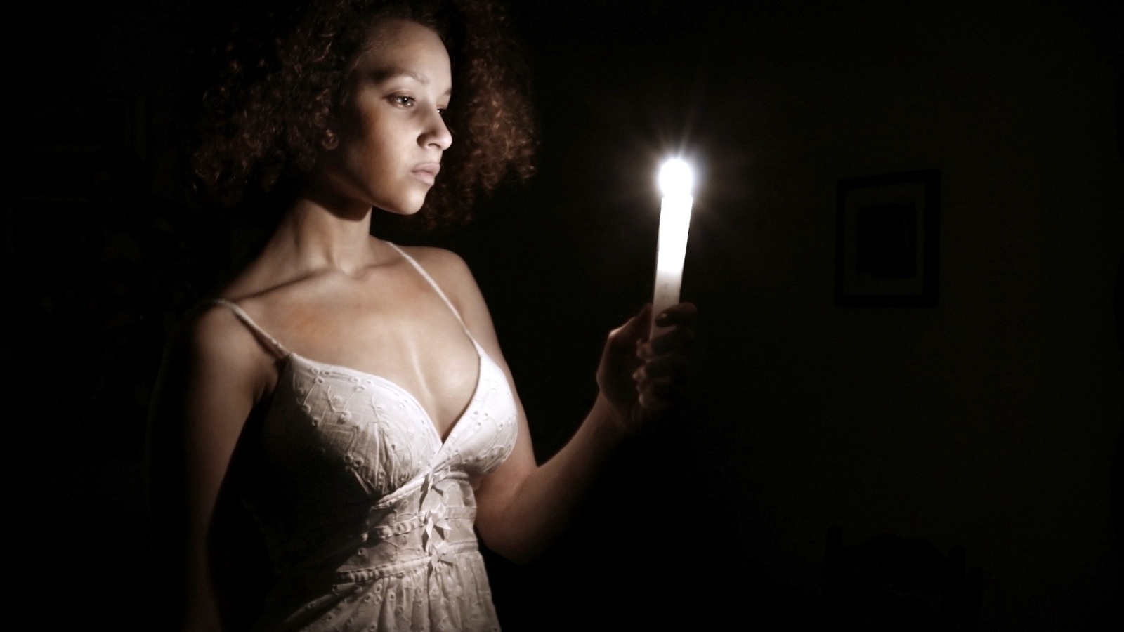 Девушка со свечой в темноте