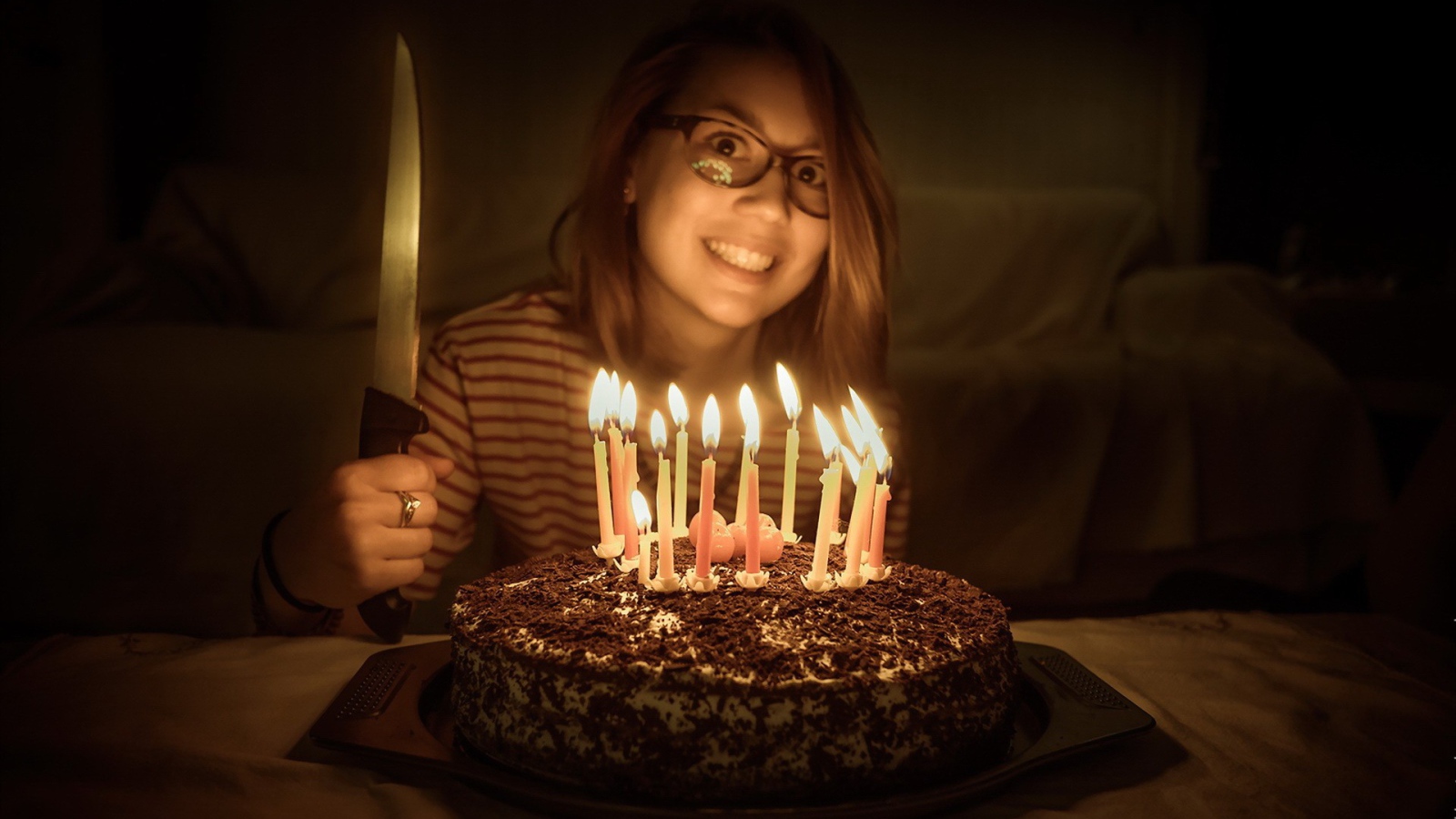 Девушка с ножом у праздничного торта