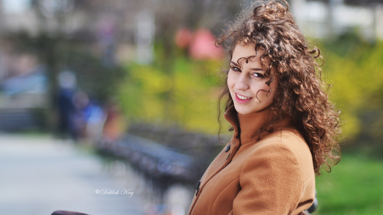 Ветер треплет волосы кучерявой девушки