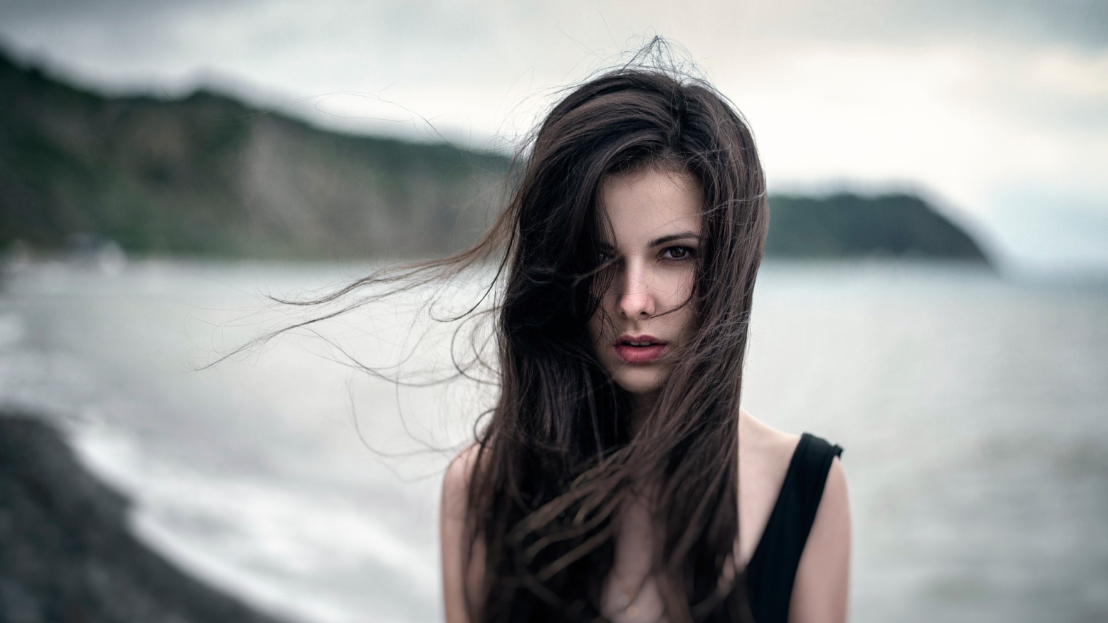 Ветер треплет волосы девушки у моря, портрет