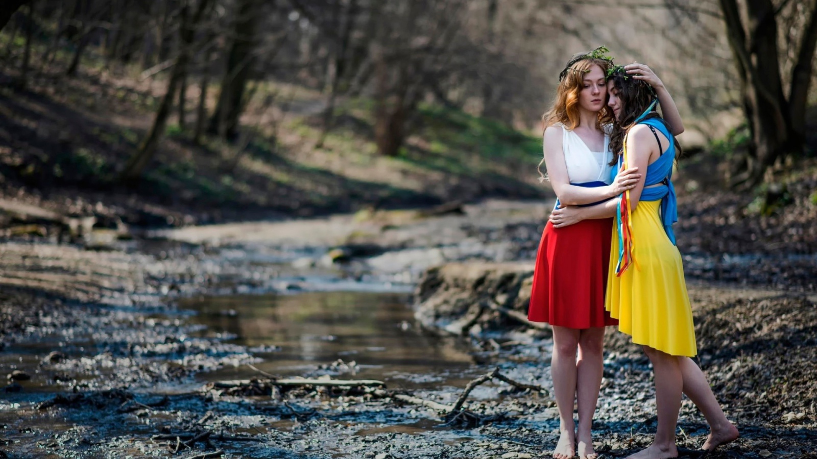 Две девушки в ярких платьях в чаще леса