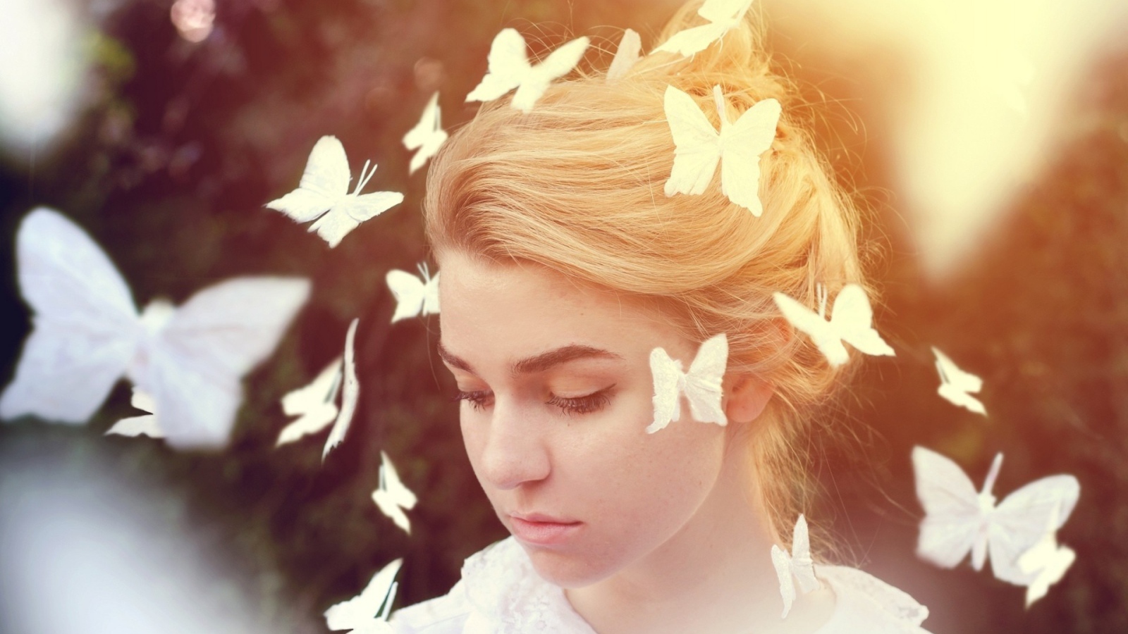 Белые бабочки летают вокруг девушки
