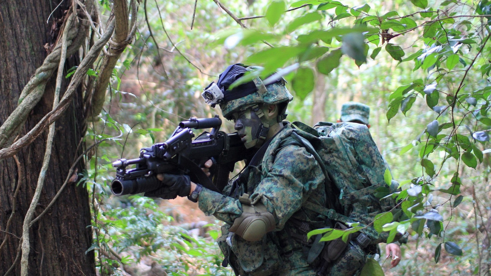 Солдат в камуфляже идет по лесу