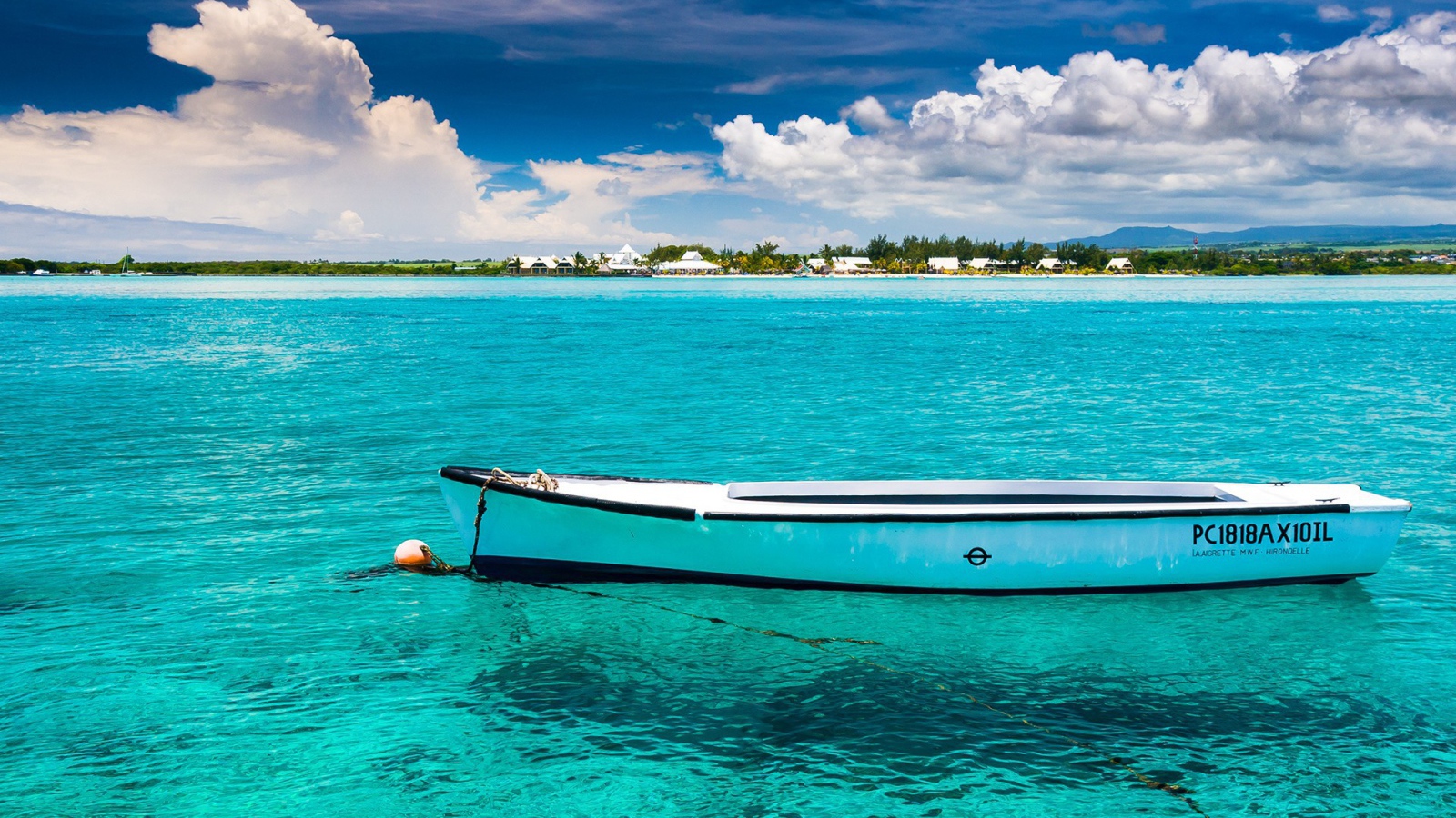 Белая лодка на голубой прозрачной воде