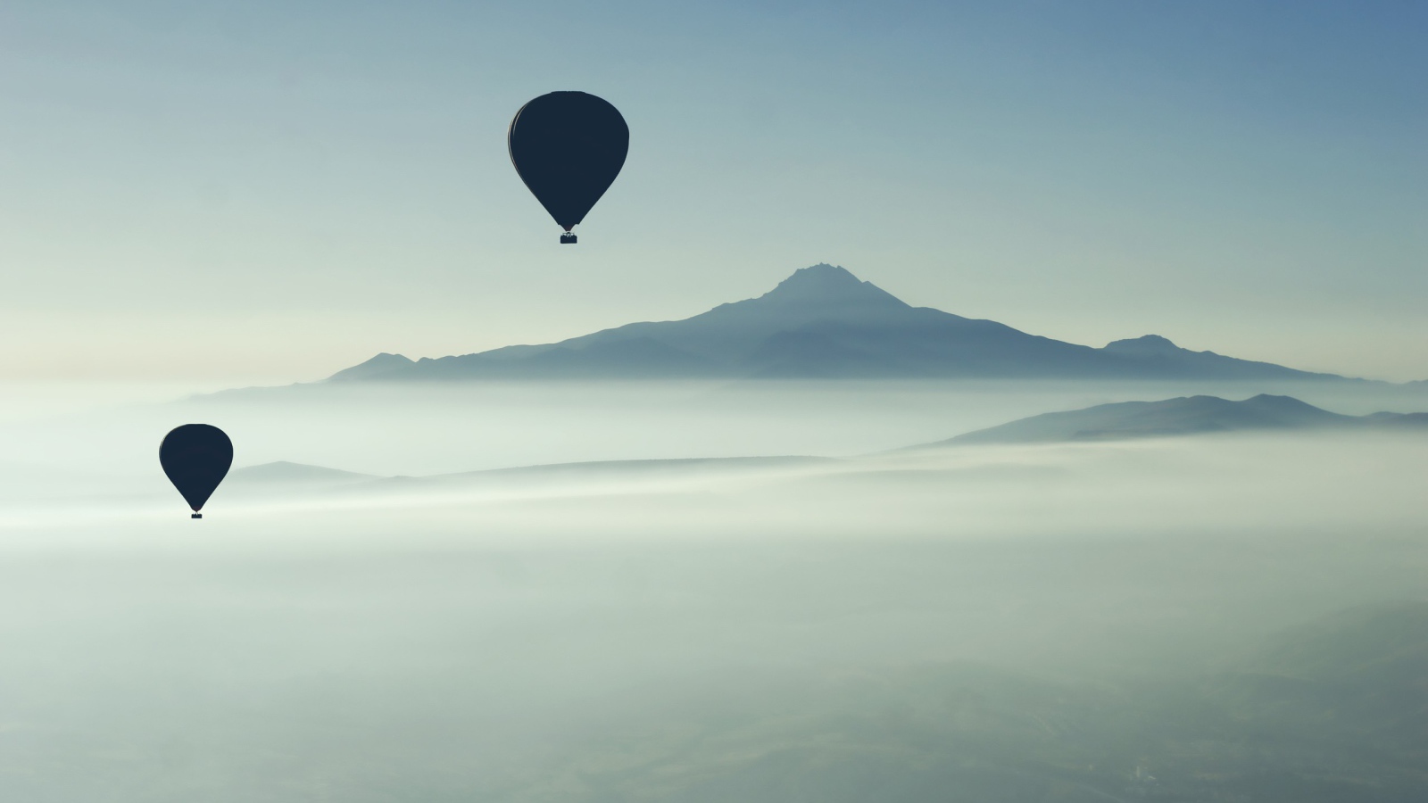 Черные воздушные шары над туманом