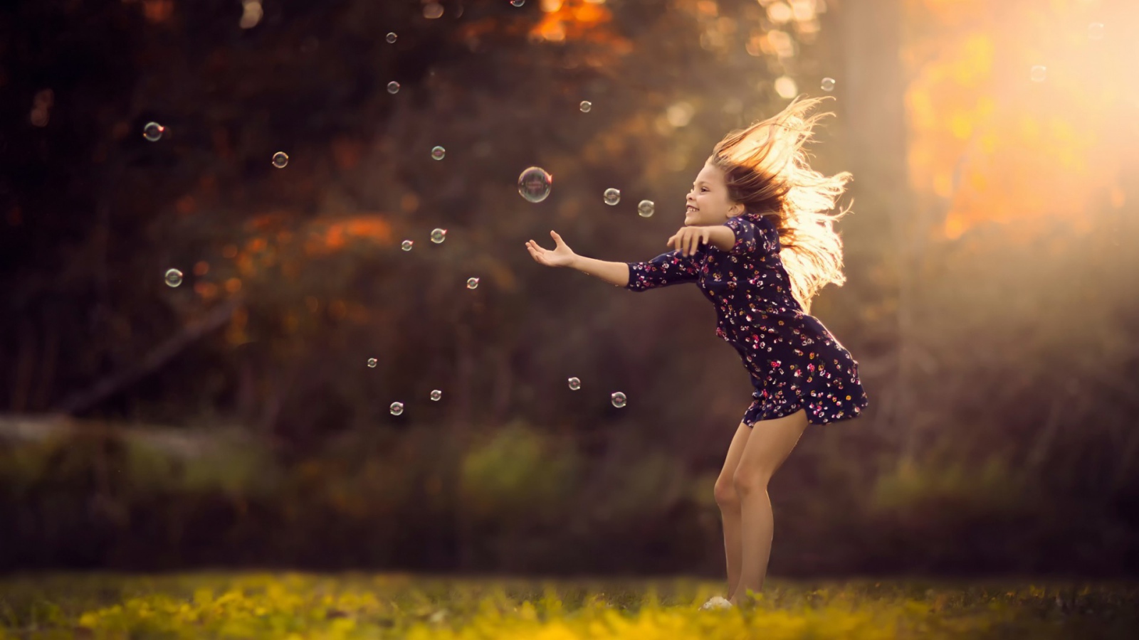Девочка играет с мыльными пузырями