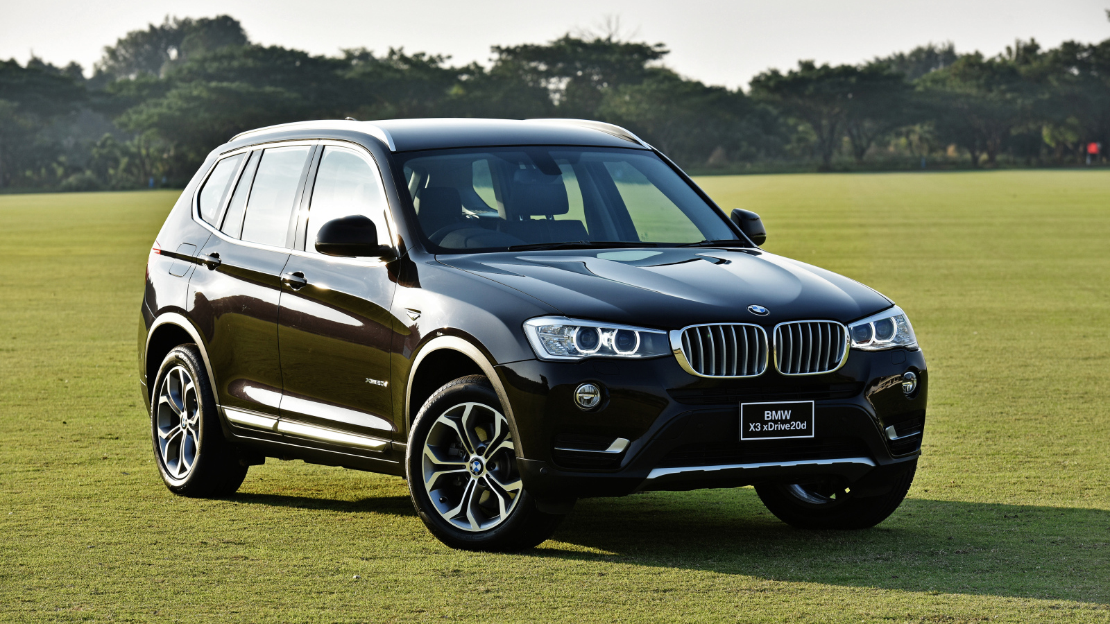 Черный автомобиль  BMW X3 на поле для гольфа 