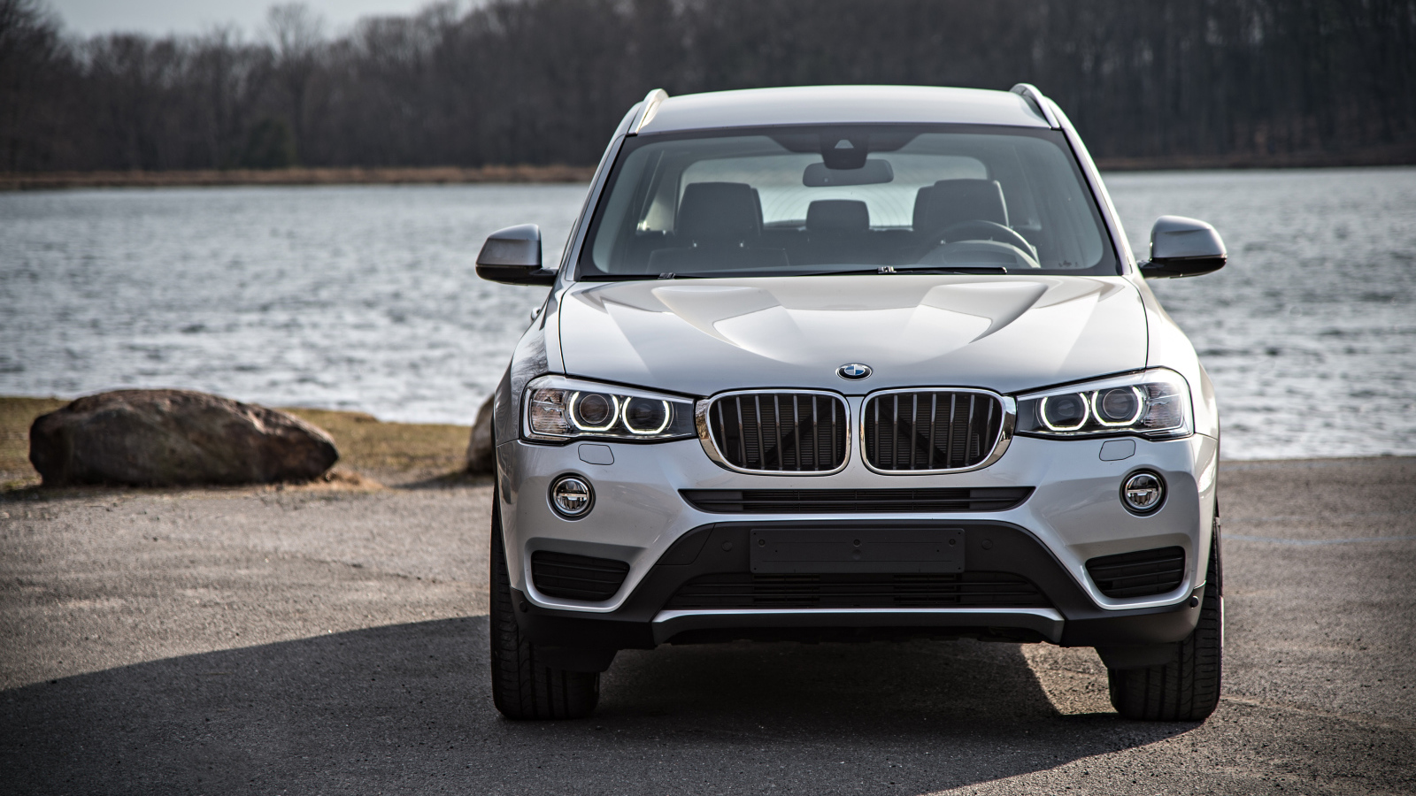 Серебристый автомобиль BMW X3 у водоема 