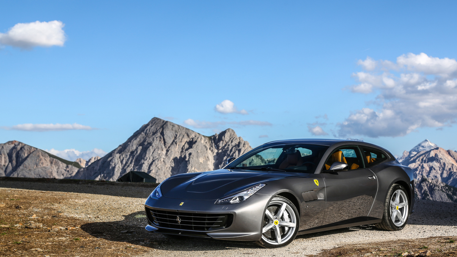 Серебристый автомобиль Ferrari GTC4Lusso на фоне голубого неба 