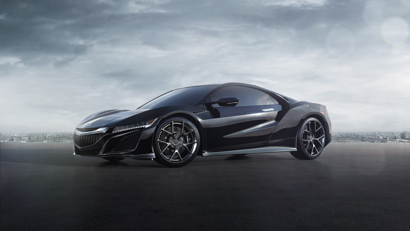 Черный спортивный автомобиль Honda NSX под пасмурным небом