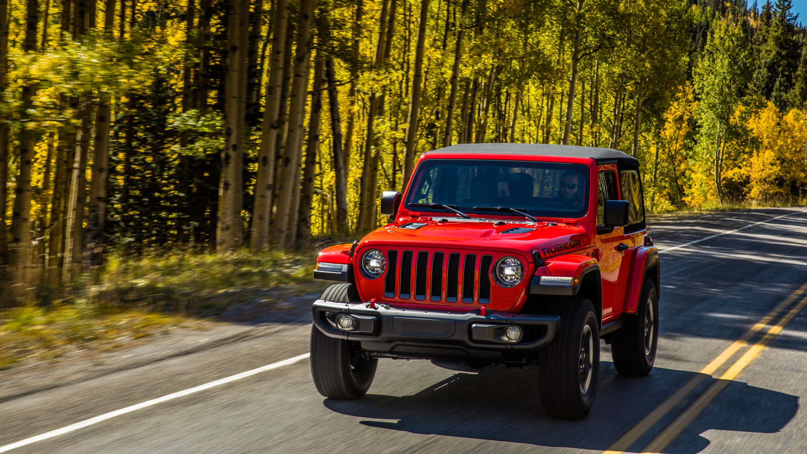 Красный автомобиль Jeep Wrangler Rubicon 2, 2018 на лесной трассе