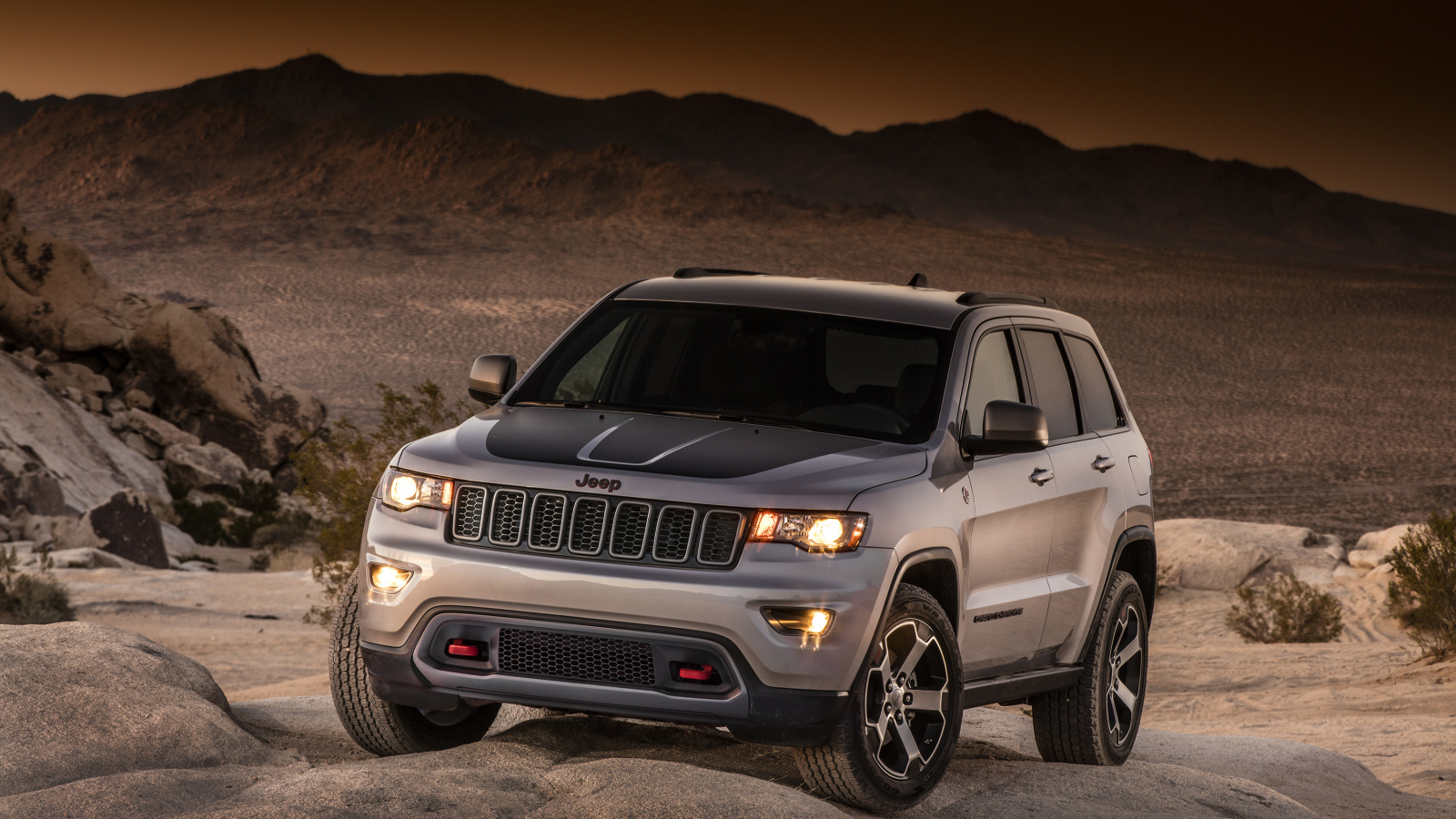 Серебристый внедорожник Jeep Grand Cherokee в пустыне 