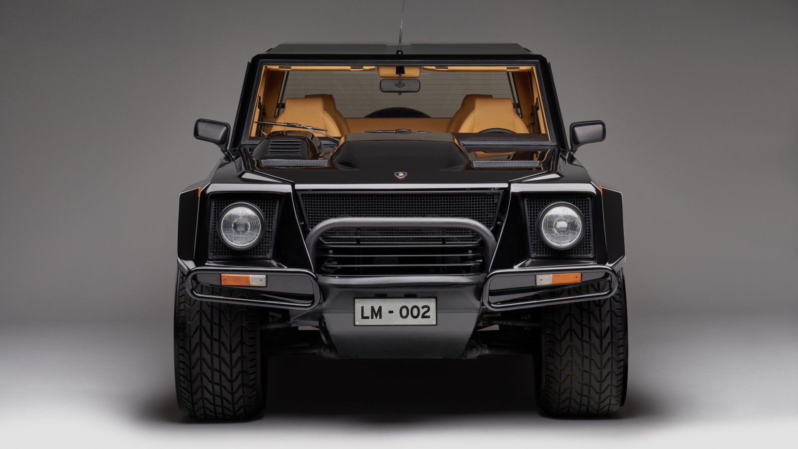 Черный автомобиль Lamborghini LM002 на сером фоне