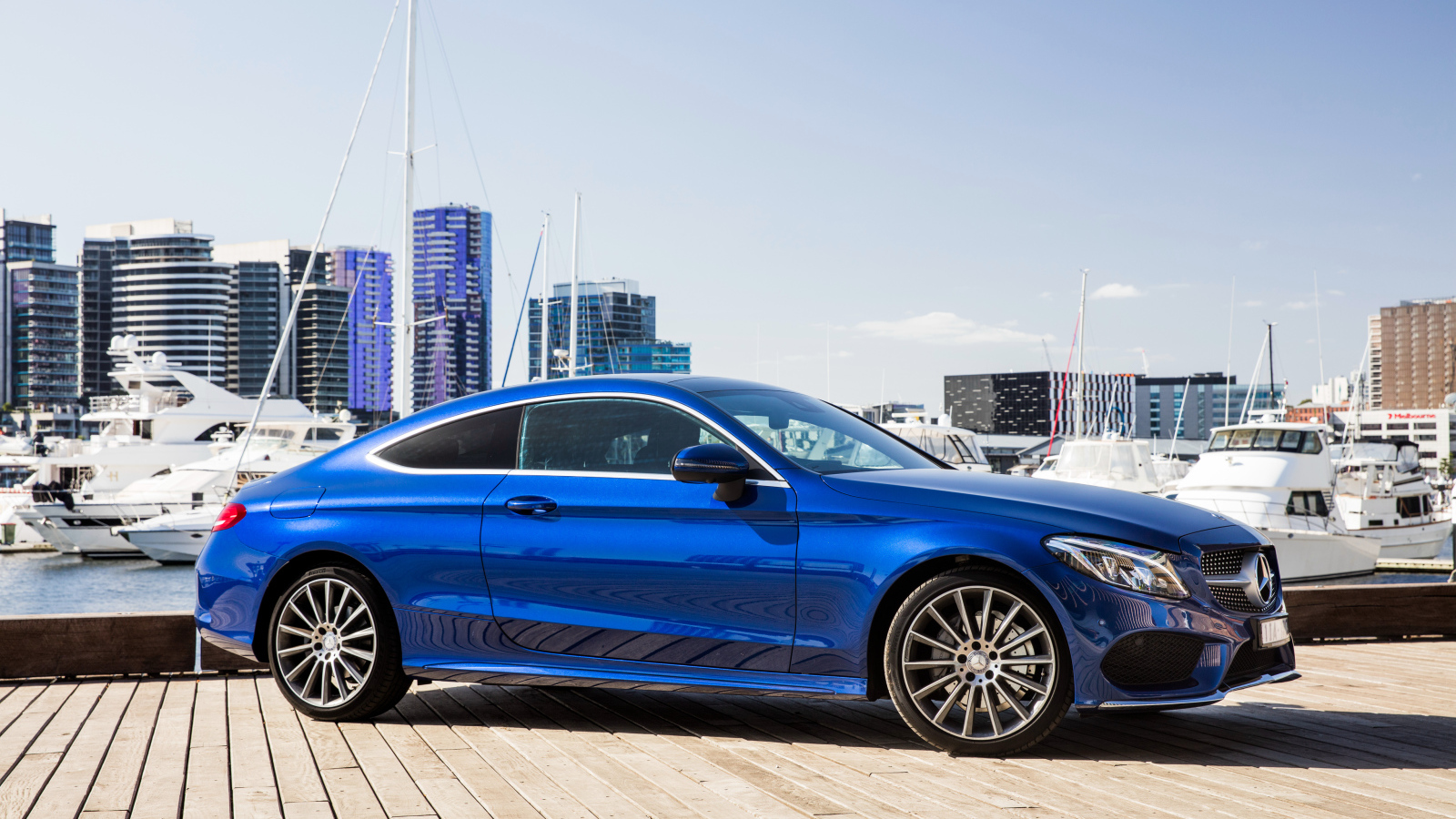 Синий автомобиль Mercedes-Benz C205 на фоне города