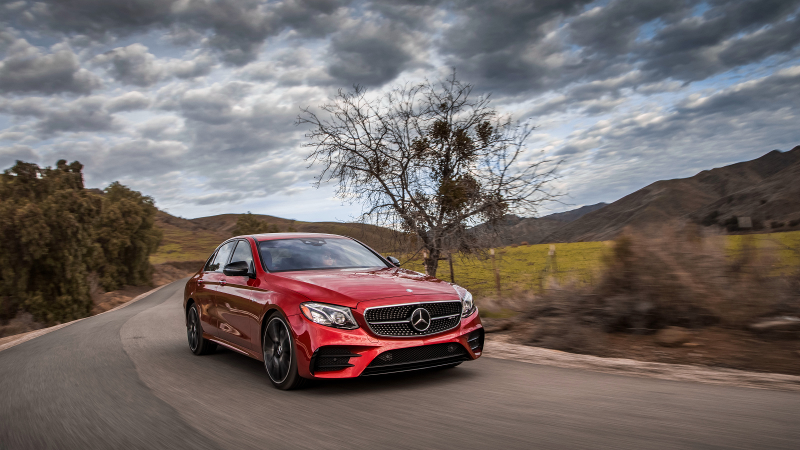 Стильный красный автомобиль Mercedes-Benz E-Class на фоне неба 